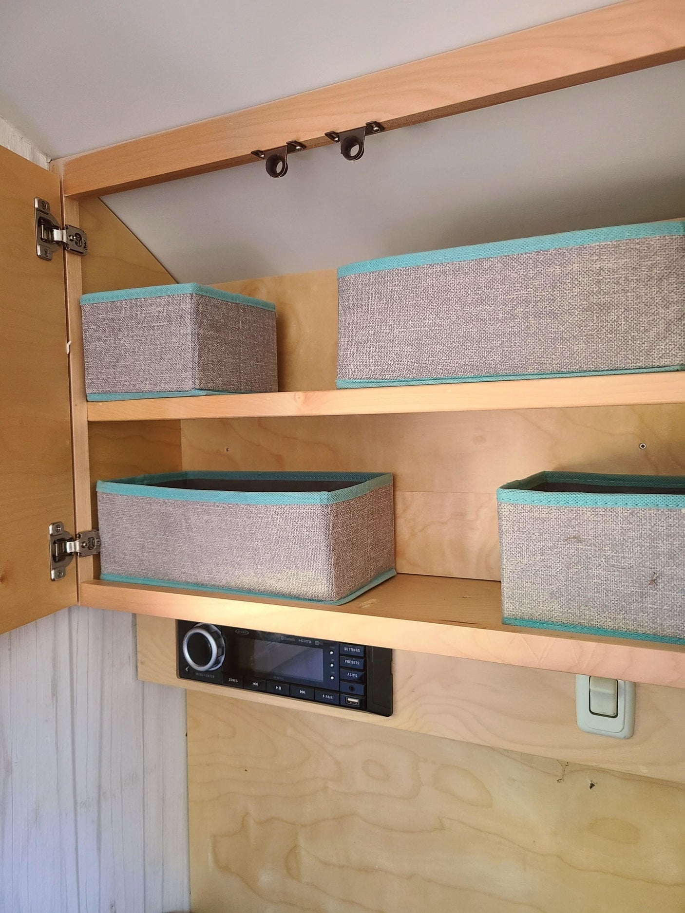 and windows showcasing a serene forest view.|Cozy RV rental interior with decorative bunting