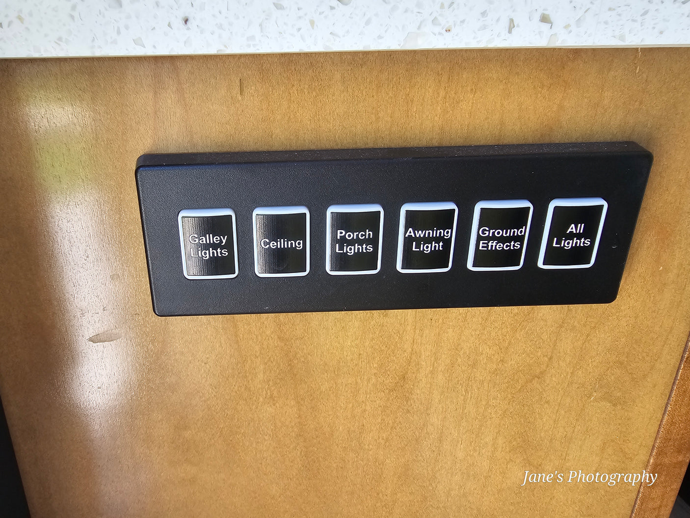 RV rental interior light control panel. Clearly labeled buttons for Galley, Ceiling, Porch, Awning, Ground Effects, and All Lights.