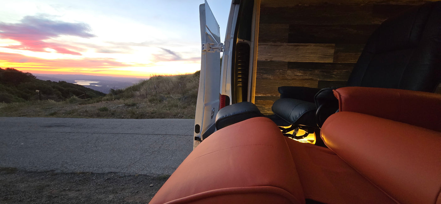 Golden hour relaxation: an rv rental with comfy seating, open to a stunning sunset, mountain, and lake view.
