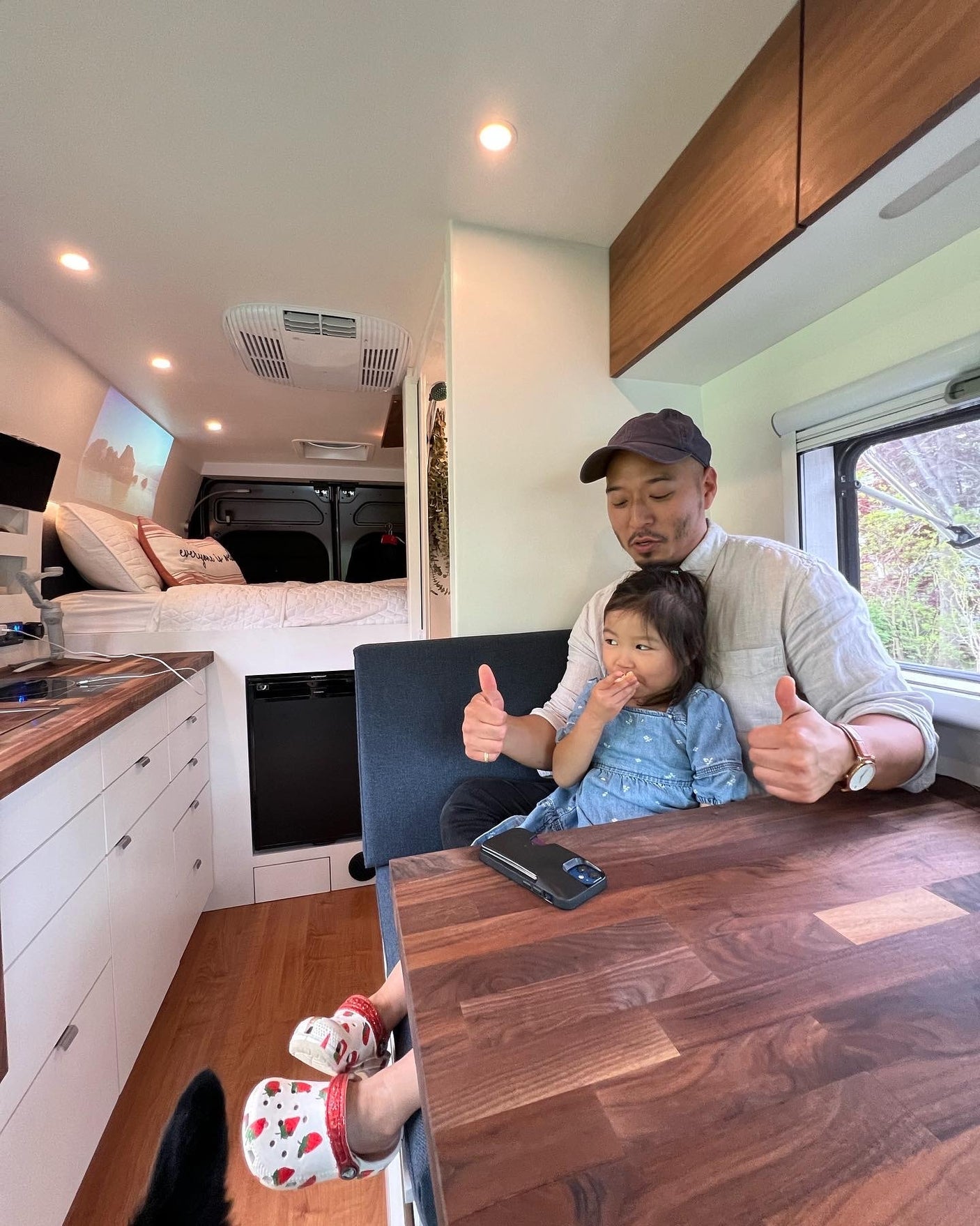 power outlets & wood floor.|Woman utilizing smart kitchen storage in a modern RV rental