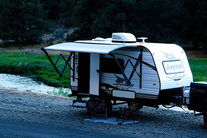 featuring a travel trailer with extended awning and cozy outdoor seating.|This white travel trailer RV rental