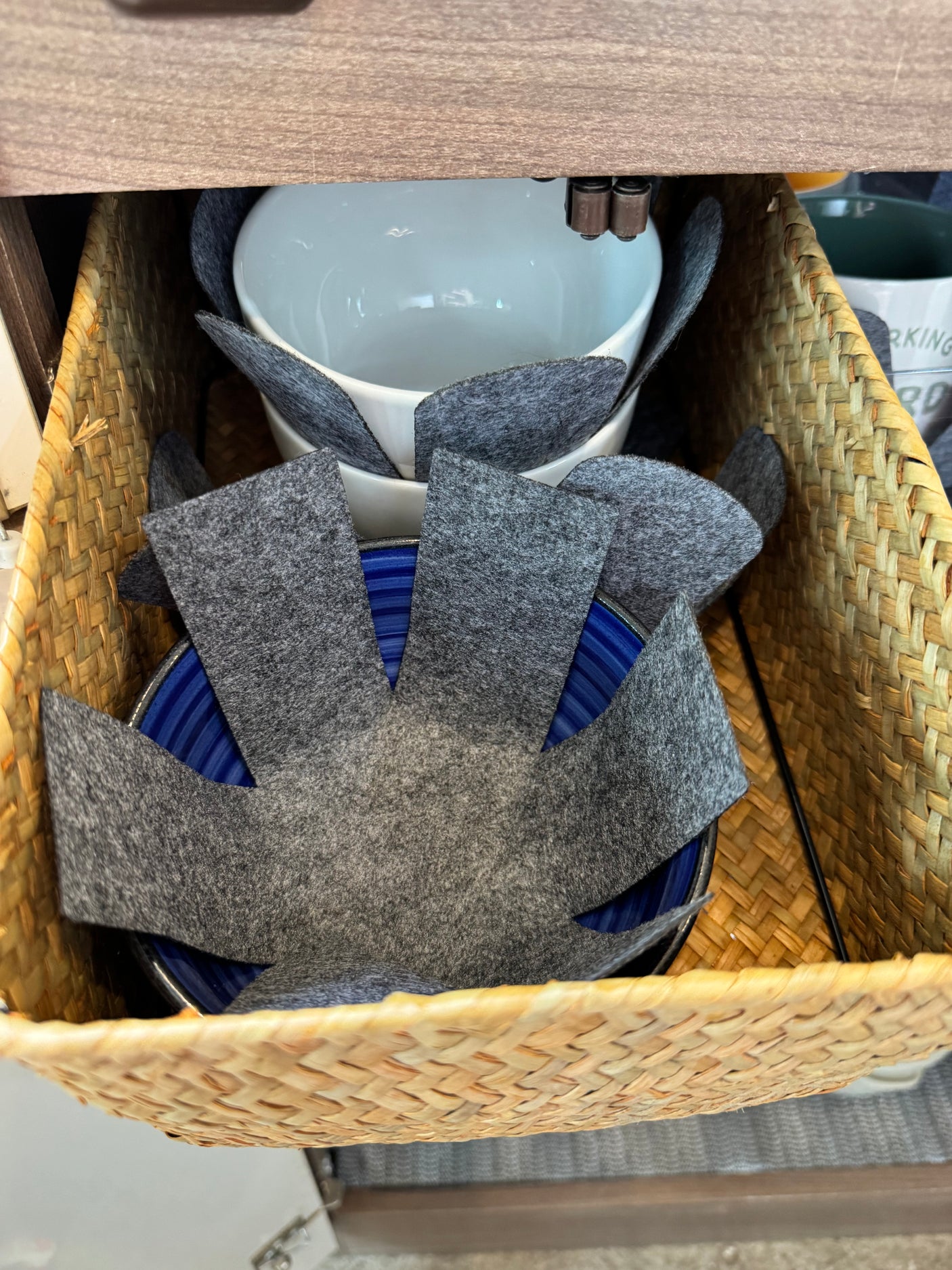 Organized kitchenware in an RV rental: Stacked bowls with felt protectors sit securely in a woven basket drawer.