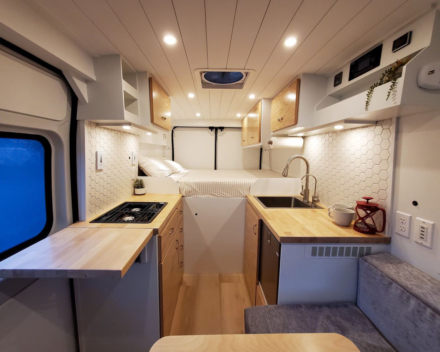 Bright and functional rv rental camper van interior with kitchenette, bed, and dining nook. Modern design perfect for adventurers.