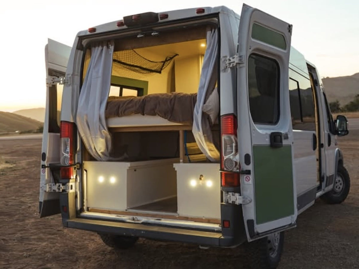 This RV rental camper van opens to a cozy interior with a bed — photo 1