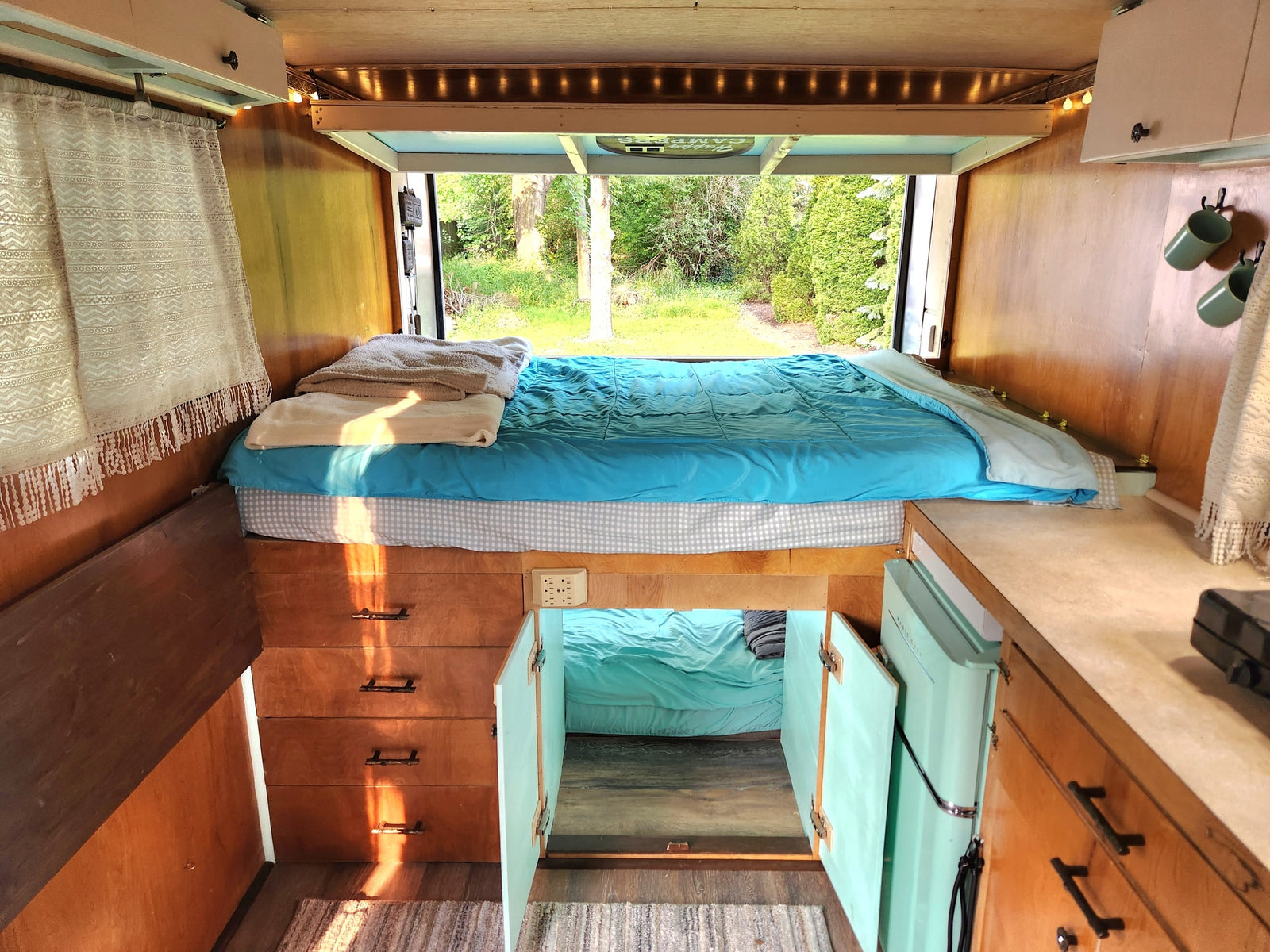 seen from behind on green grass. Ideal for hauling or as an **RV rental** alternative.|Silver cargo trailer