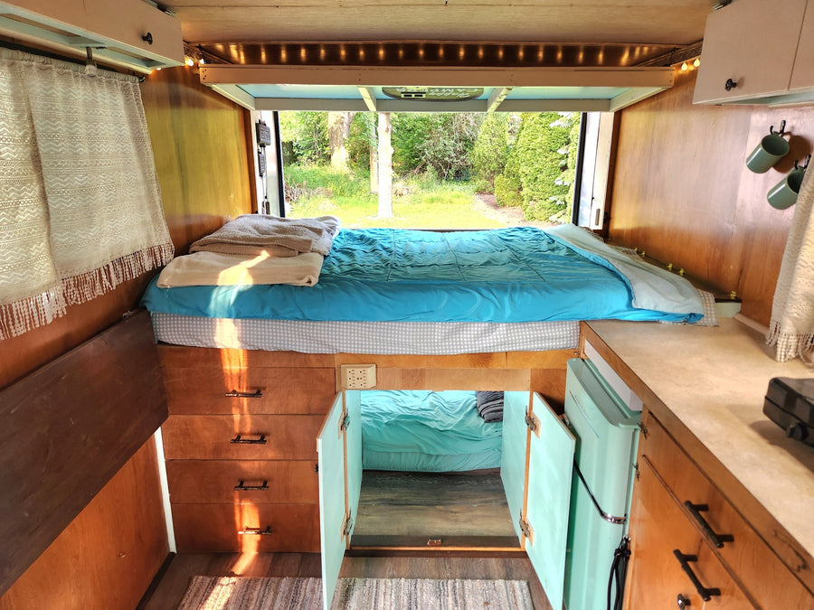 seen from behind on green grass. Ideal for hauling or as an **RV rental** alternative.|Silver cargo trailer