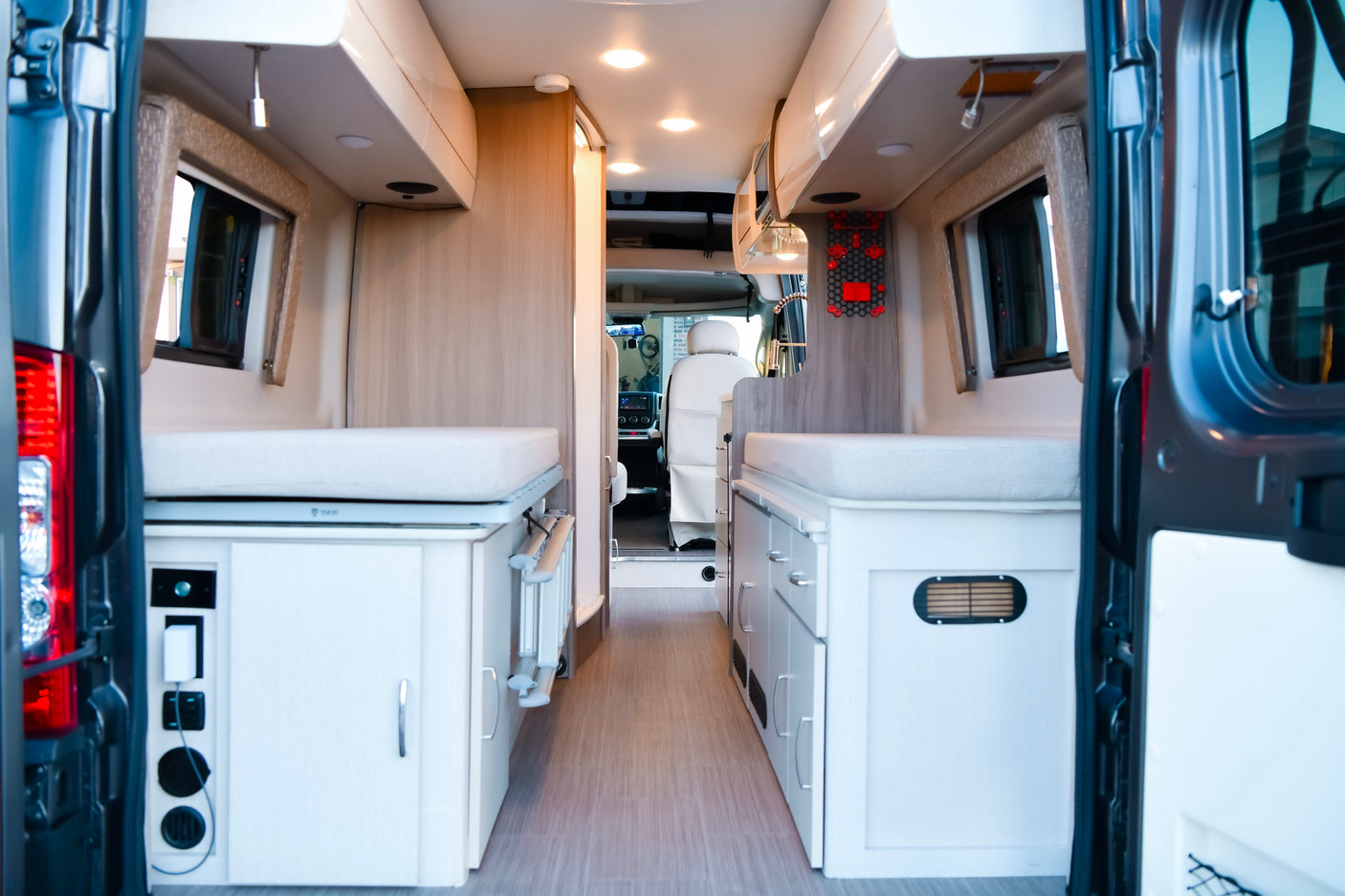 Modern camper van rv rental interior, featuring dual sleeping areas, ample storage, and a clean, functional design.