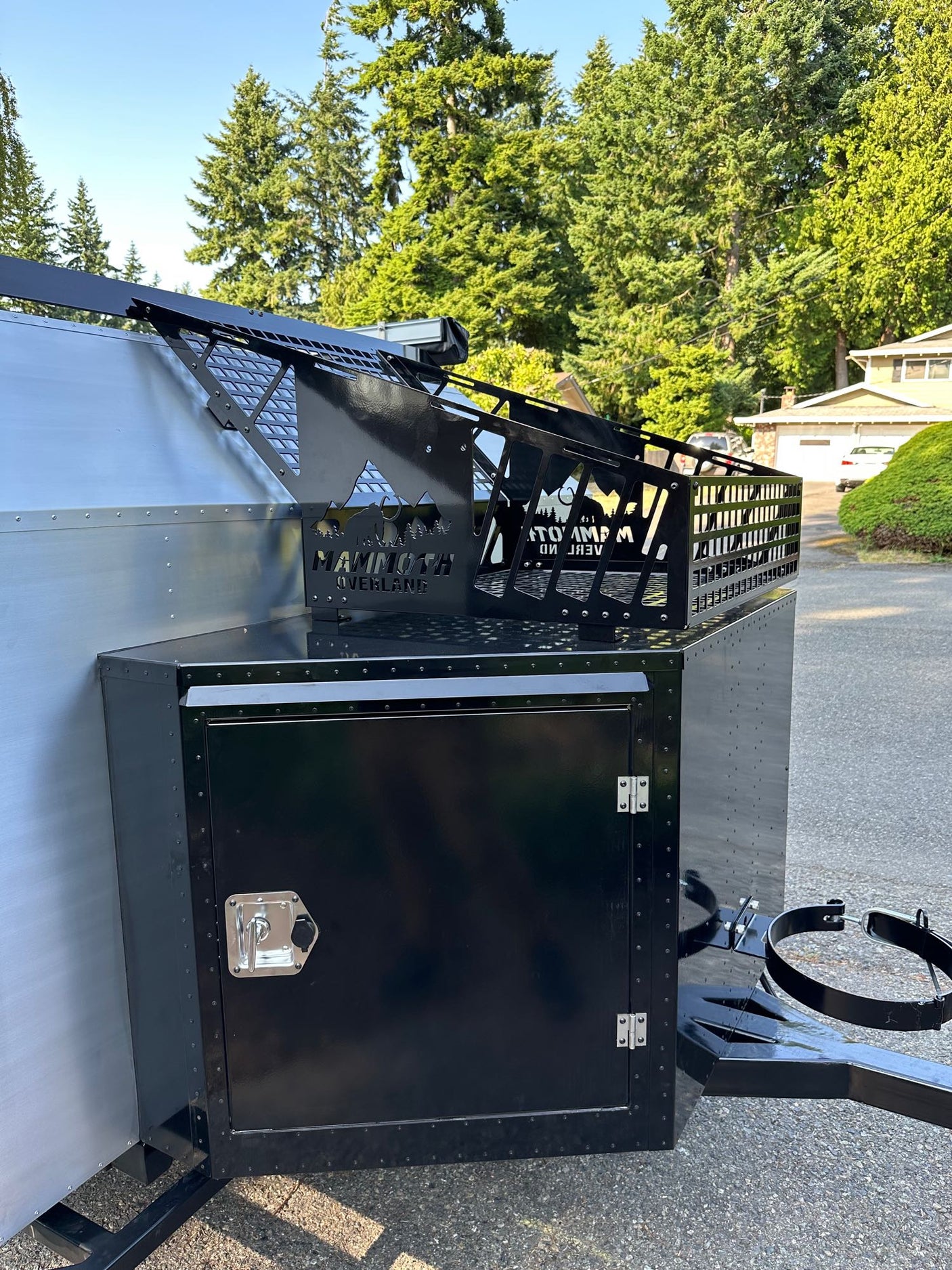 and stove ready for adventure cooking.|RV rental essential: Open portable fridge with wire basket and digital temperature control for your adventures.|RV rental: Well-organized interior storage compartment with a large black utility tray and sliding access panel.|RV rental: Clean white camper interior with new bed
