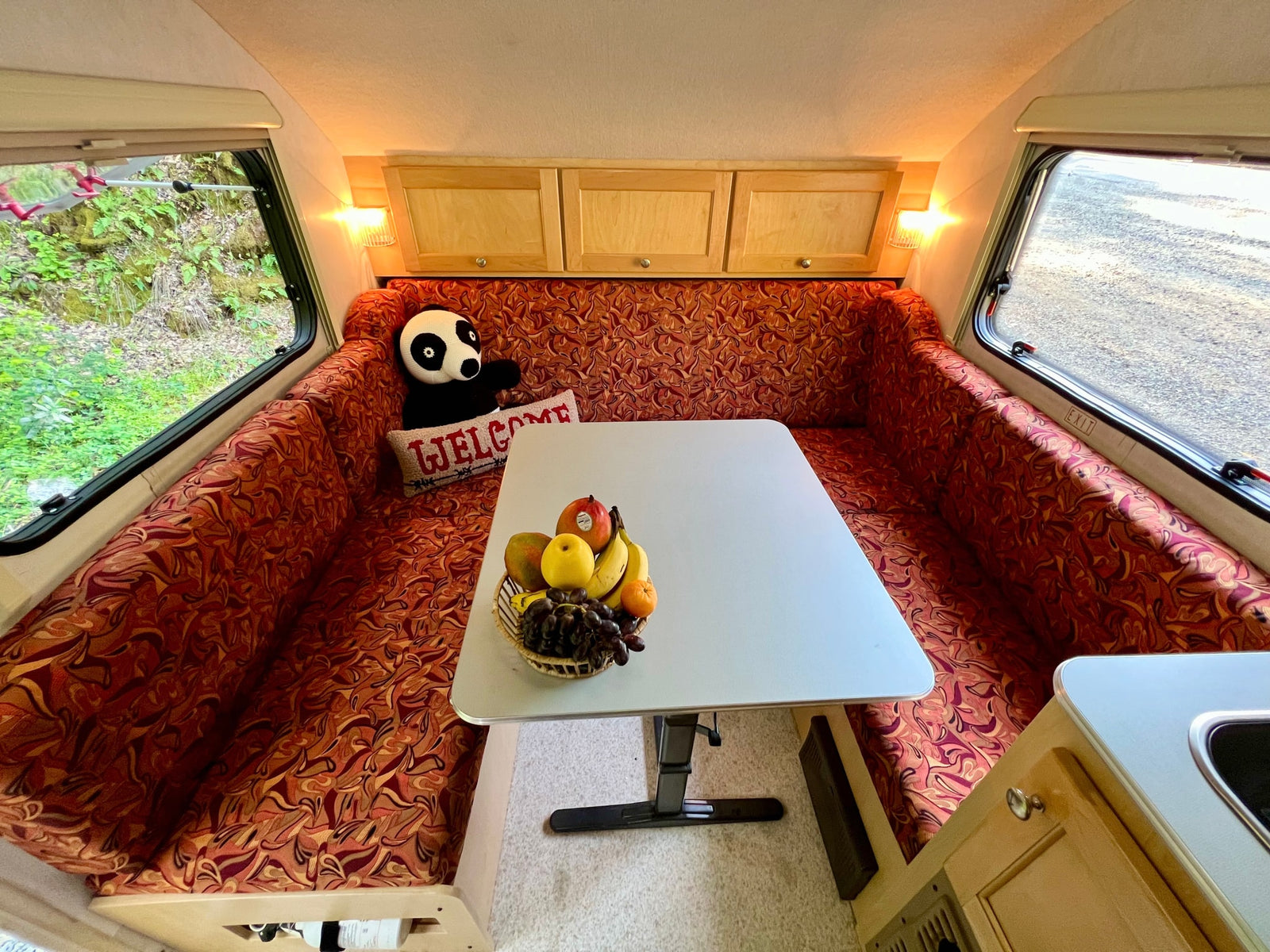 and an outdoor view.|Inside a comfortable rv rental: a well-lit dinette