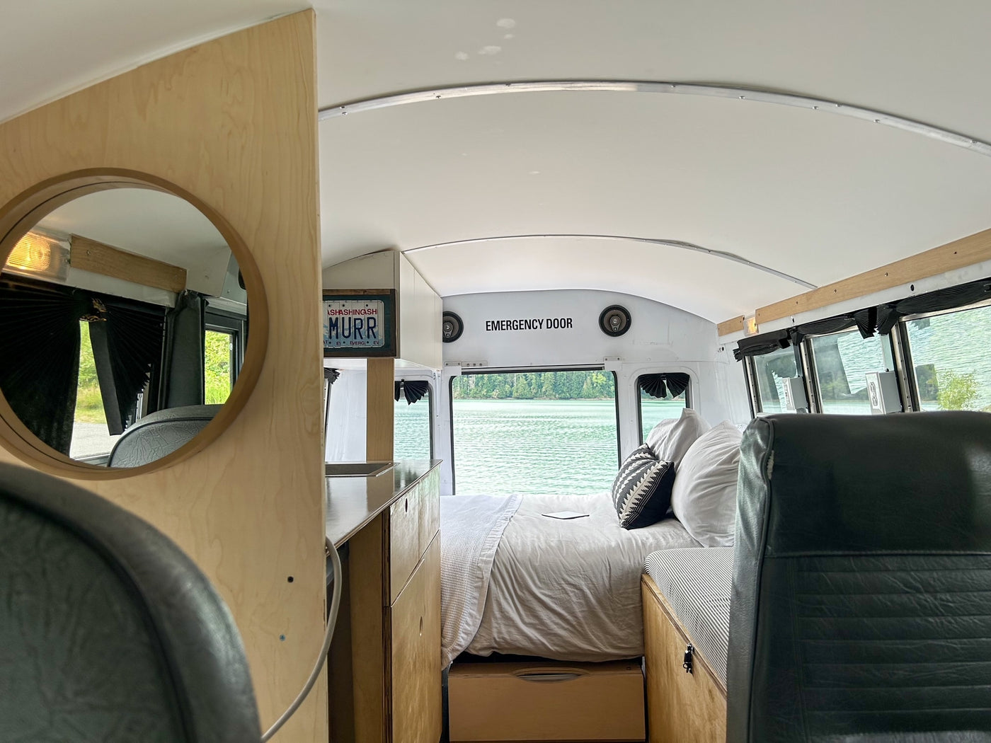 RV rental: Converted bus interior with cozy bed, kitchen, and stunning lake views, a true home on wheels. — photo 3