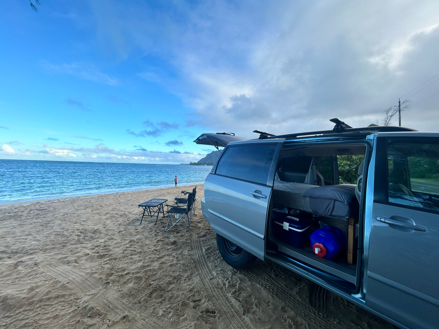 This rv rental minivan offers a cozy bed & beach views. Parked on the sand, ready for oceanfront camping & adventure.
