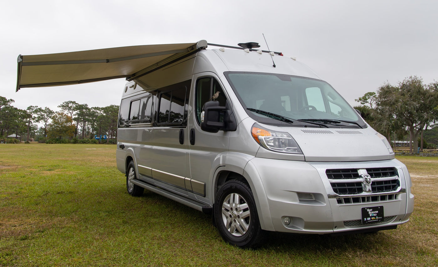 Silver camper van RV rental parked on grass — photo 1