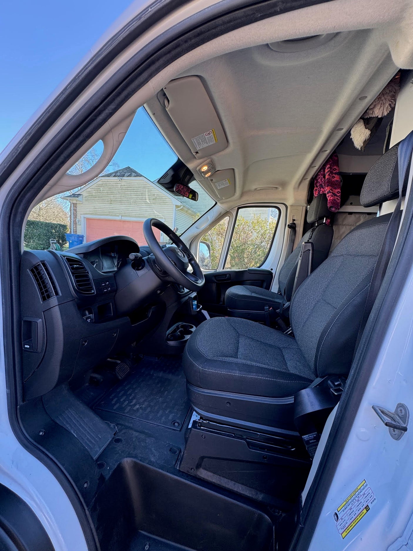 Bright interior of an rv rental van, showing the driver's cockpit with dashboard, steering wheel, and two front seats.