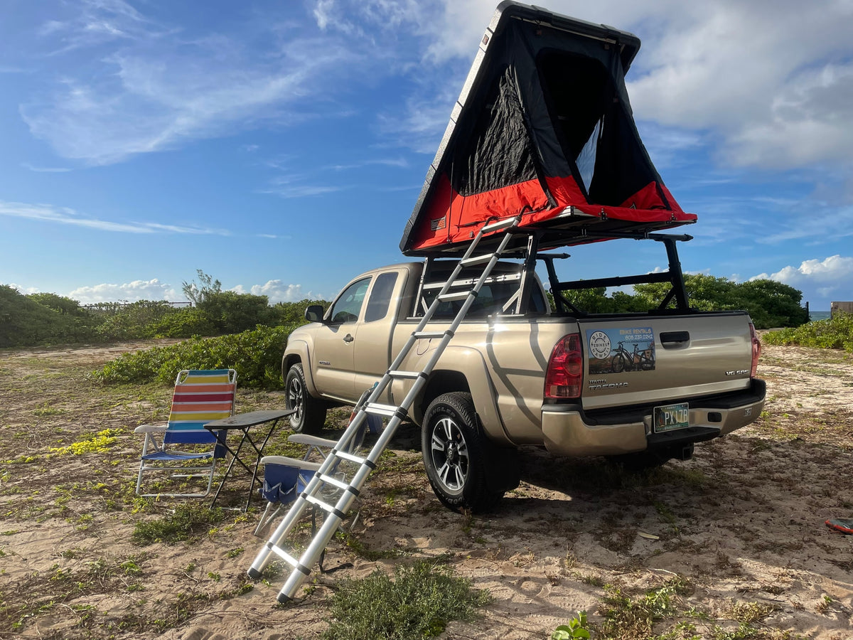 Hawaii beach camping setup: a tan truck with an open red rooftop tent & ladder, a unique RV rental experience. — photo 8