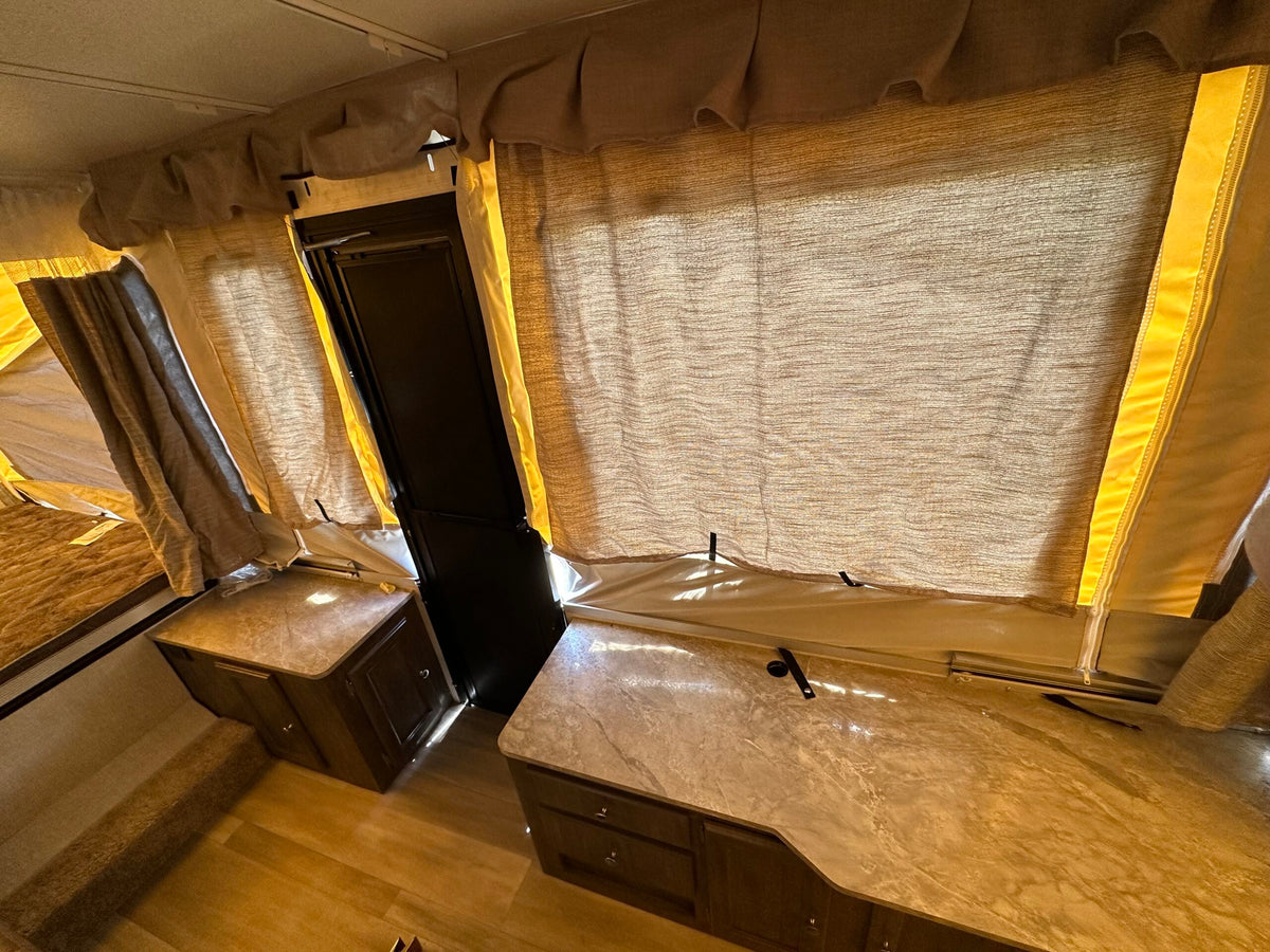 Inside an RV rental: cozy pop-up camper with sleeping area, counters, and ample natural light. — photo 7