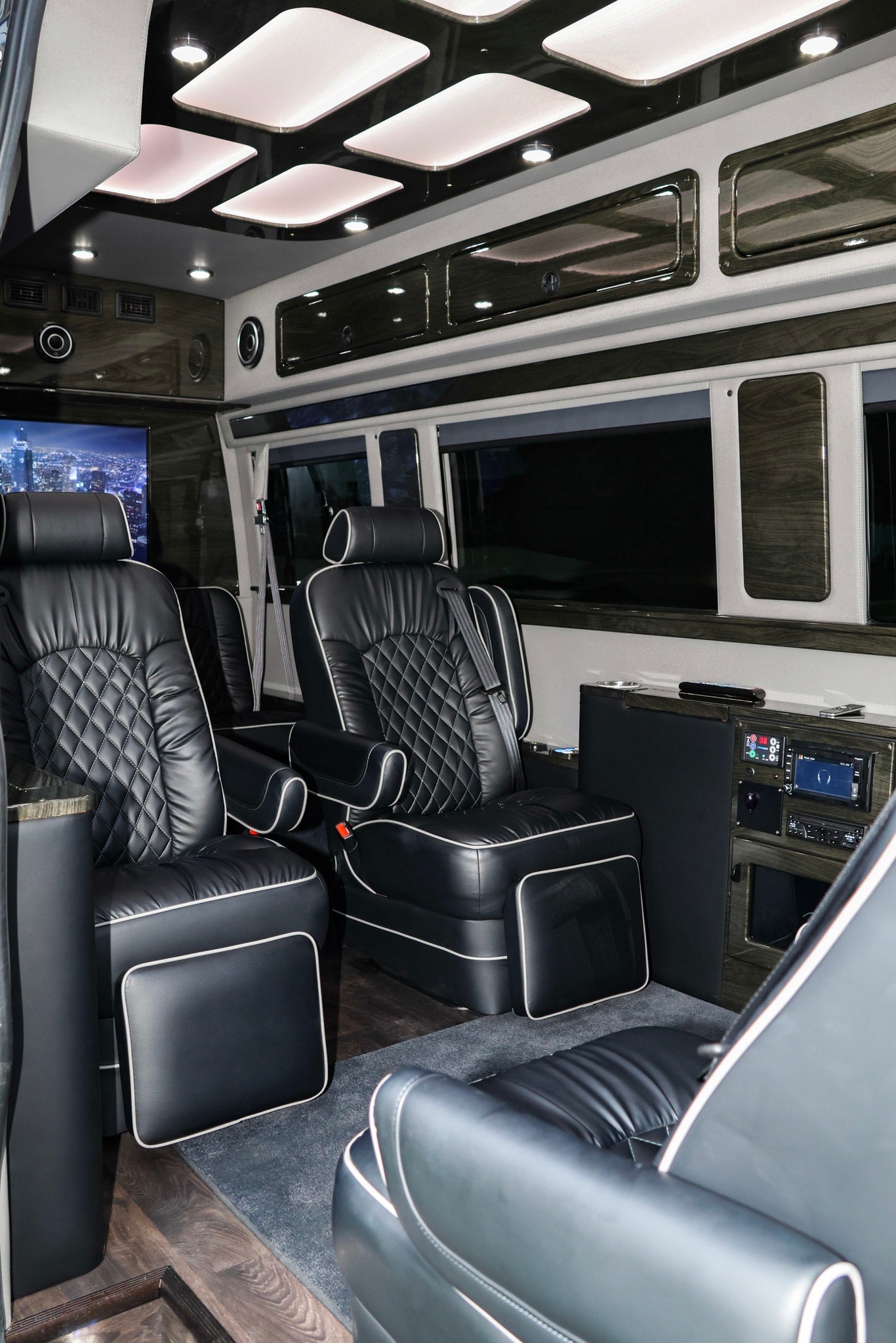 Step into luxury with this RV rental's custom interior. Featuring plush black leather captain's chairs, wood accents, and entertainment.