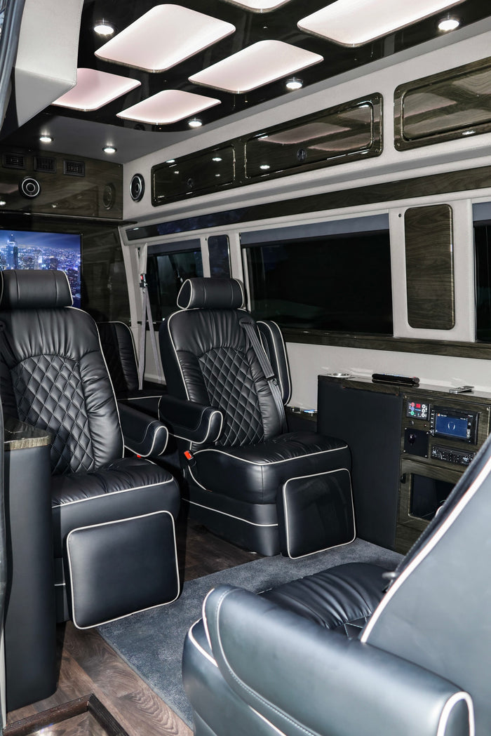 Step into luxury with this RV rental's custom interior. Featuring plush black leather captain's chairs, wood accents, and entertainment.
