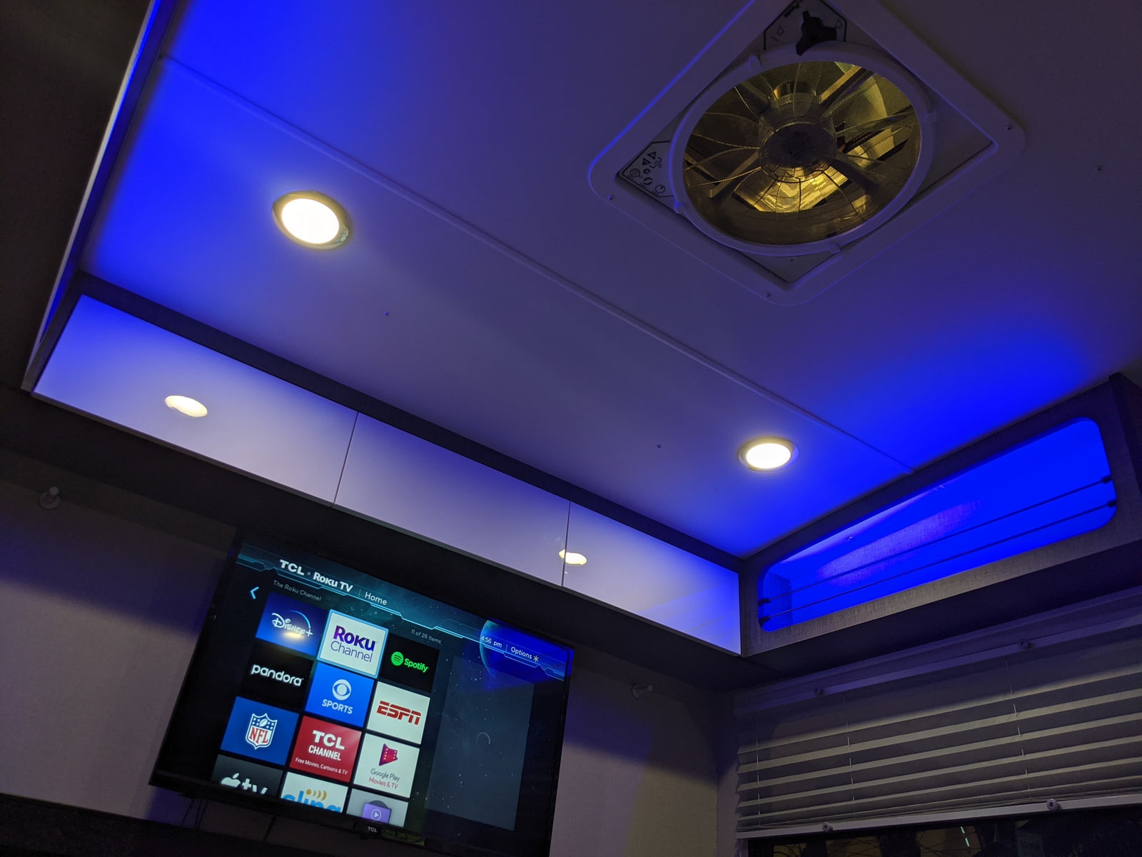 Inside an **rv rental**: Roku TV, blue LED backlighting, and a ceiling fan create a modern entertainment space.