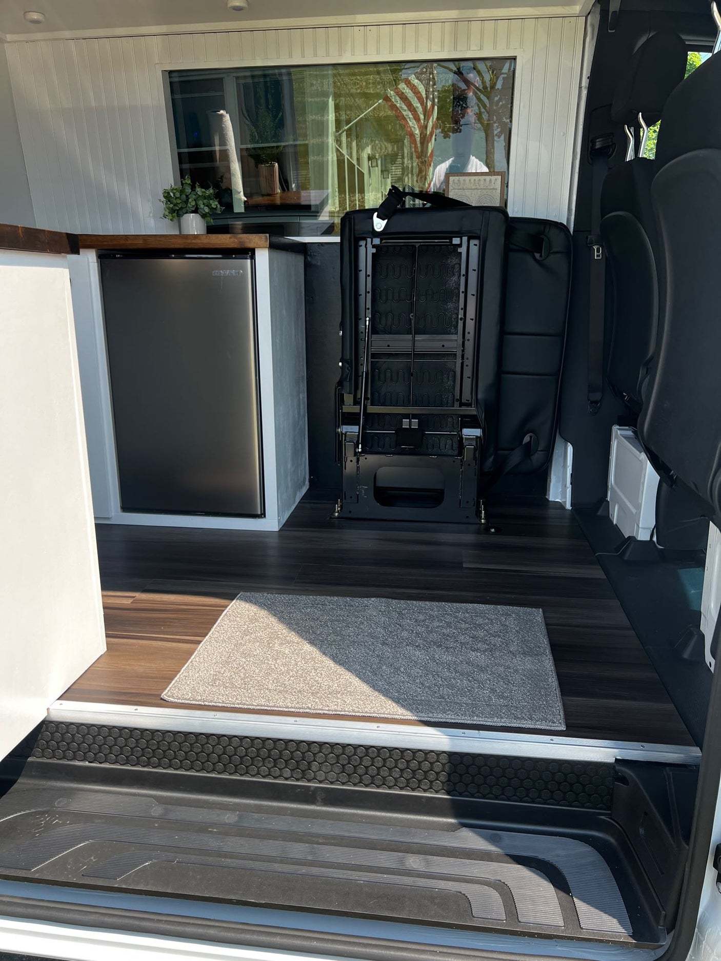 and warm lighting. Ideal for van life.|This rv rental shows a multi-functional camper van interior with a convertible bed