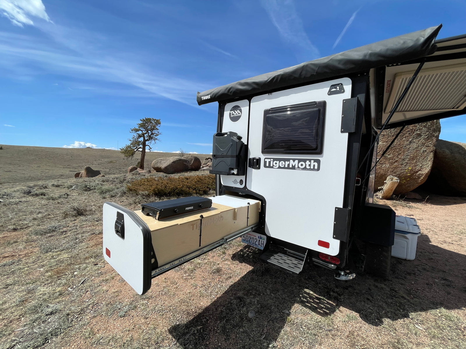 TigerMoth RV rental camping trailer with pull-out kitchen, set up for outdoor adventure.