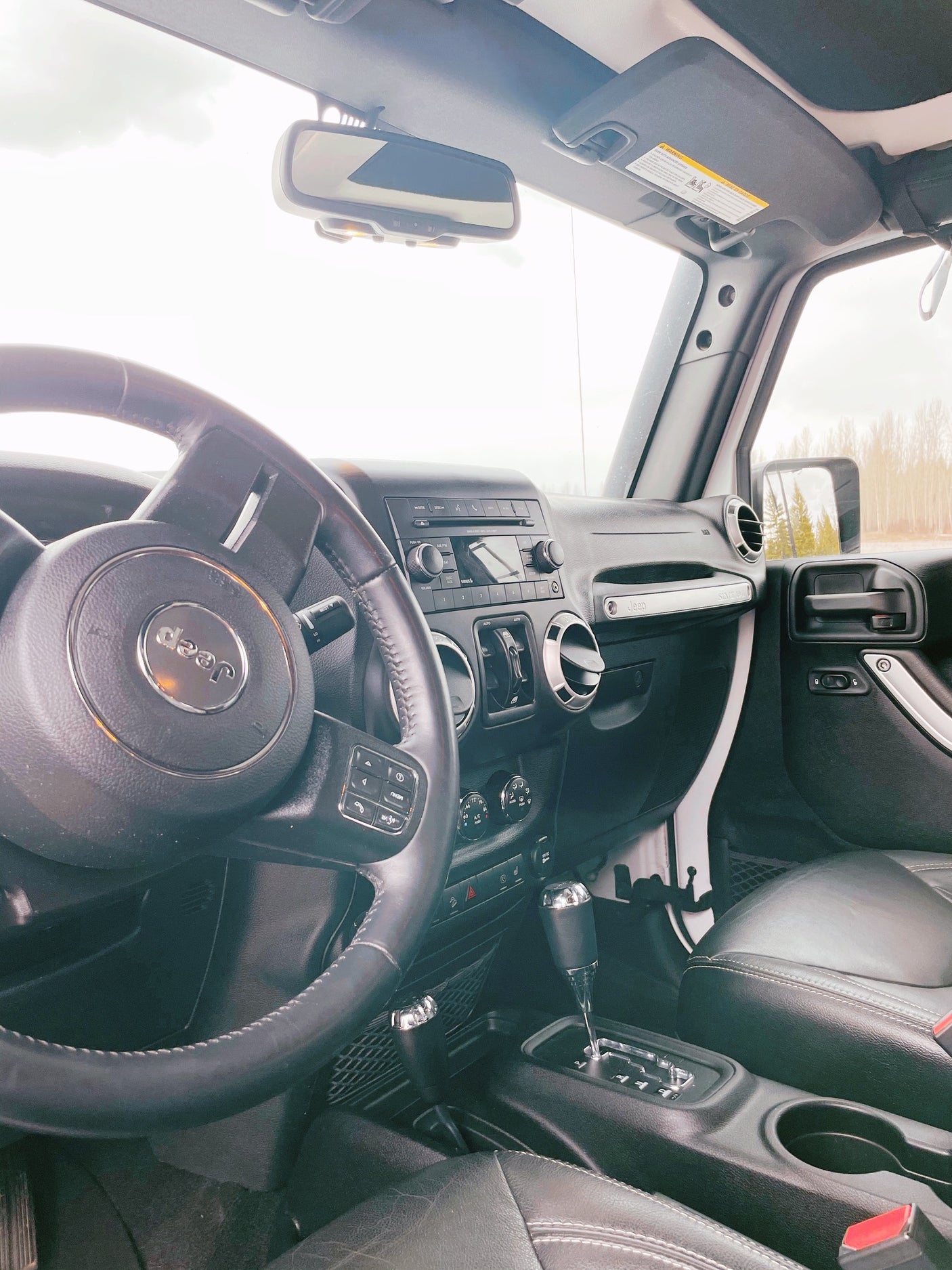 View from inside a Jeep, showing the steering wheel, dashboard, and gear shifter. Great for any RV rental trip!