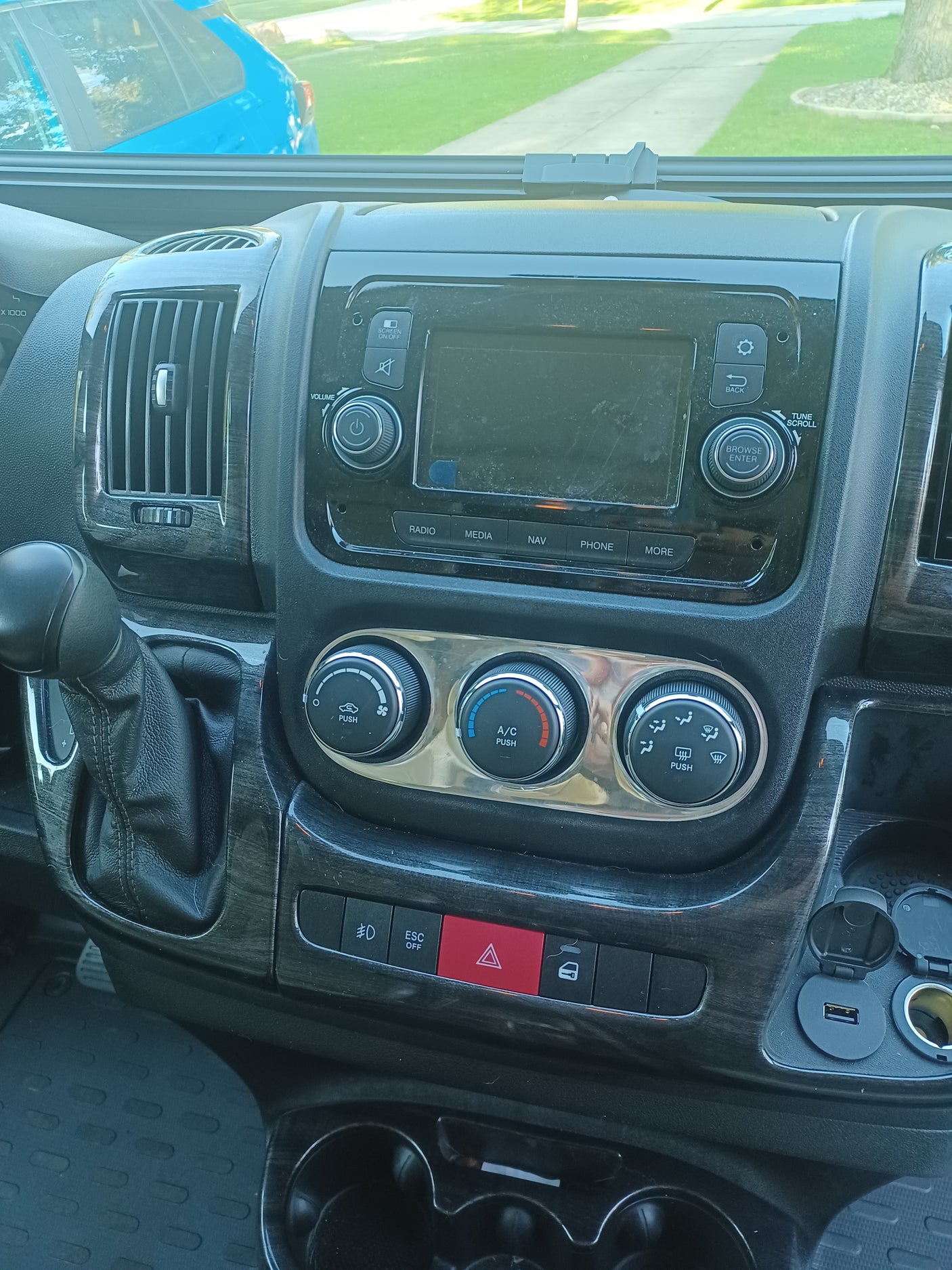 Inside an RV rental: detailed view of the modern dashboard & center console with screen, climate, and driving controls.