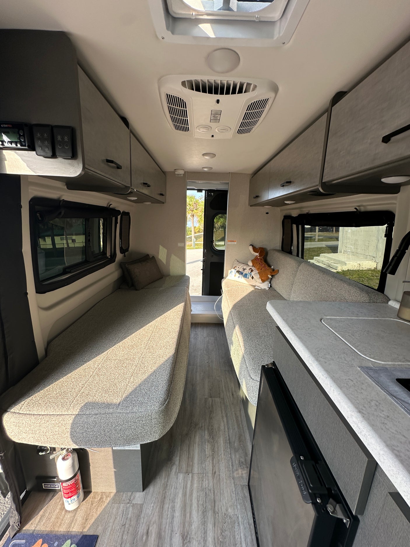 Bright rv rental interior: twin beds/sofas, compact kitchen, and overhead storage for your next adventure.