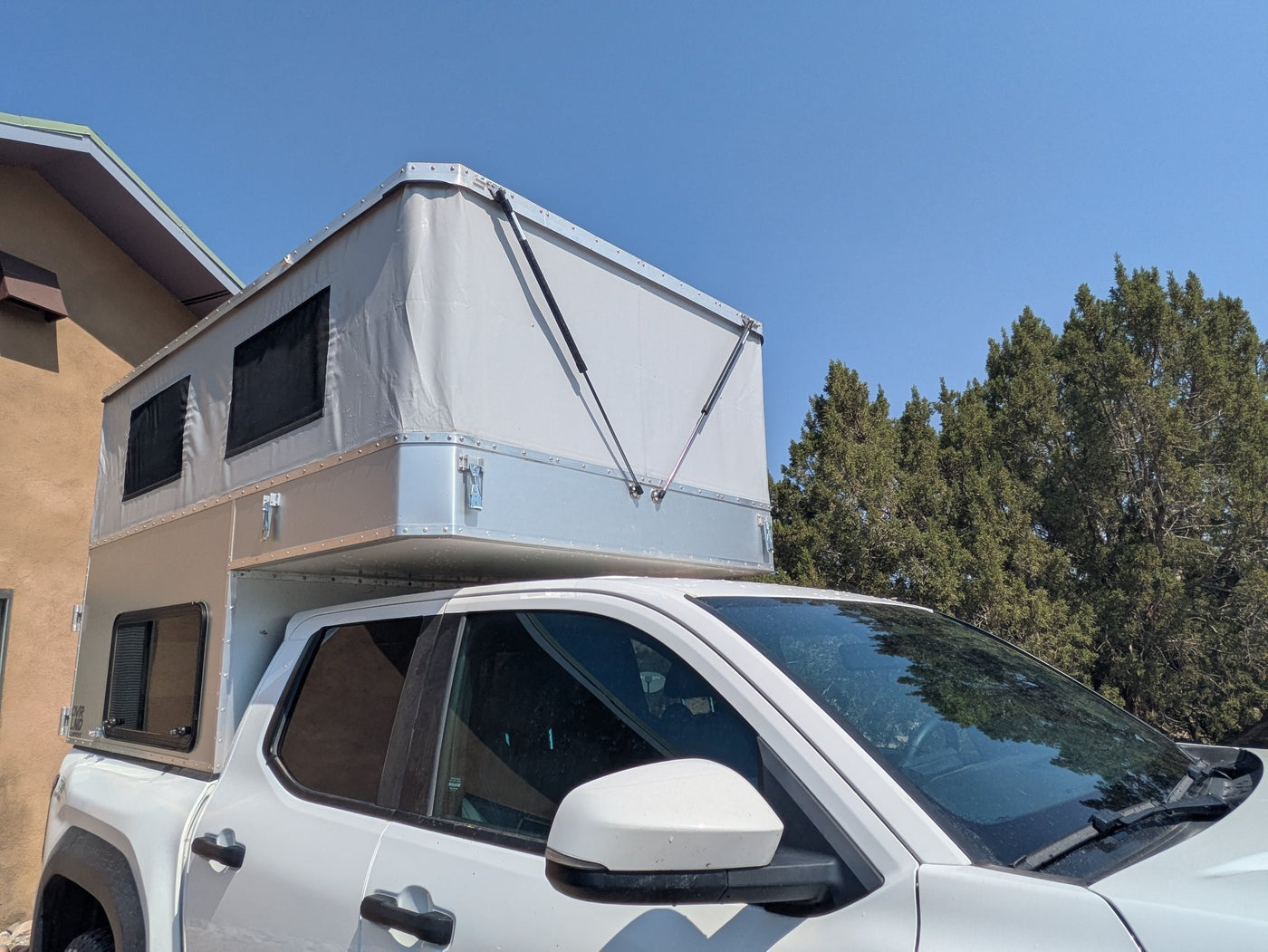 Camper in travel mode with the roof down, seen from the front of the truck — photo 5