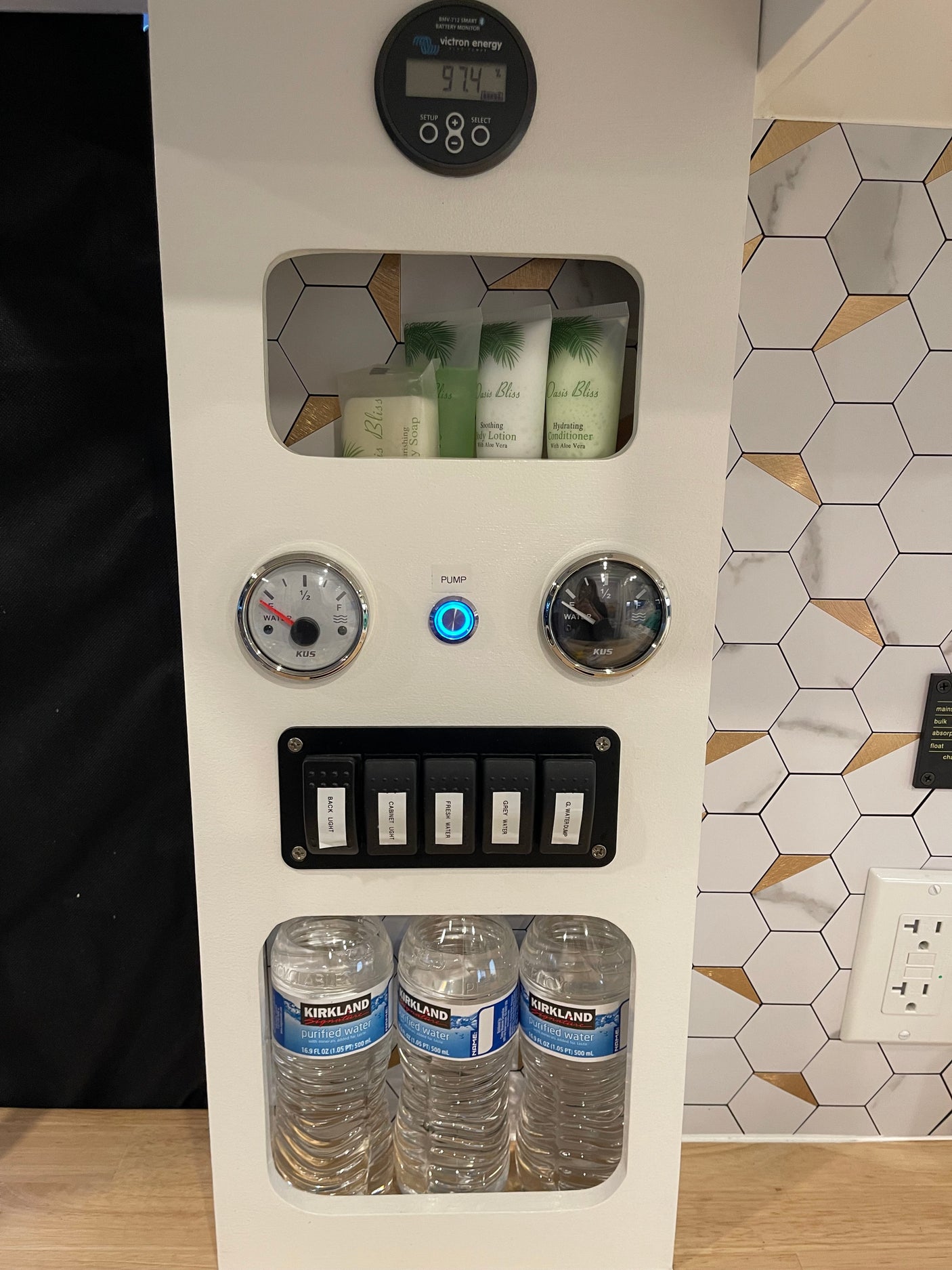 RV rental control panel: 97.4% battery, water gauges, pump, fresh/grey water switches, toiletries, and bottled water.