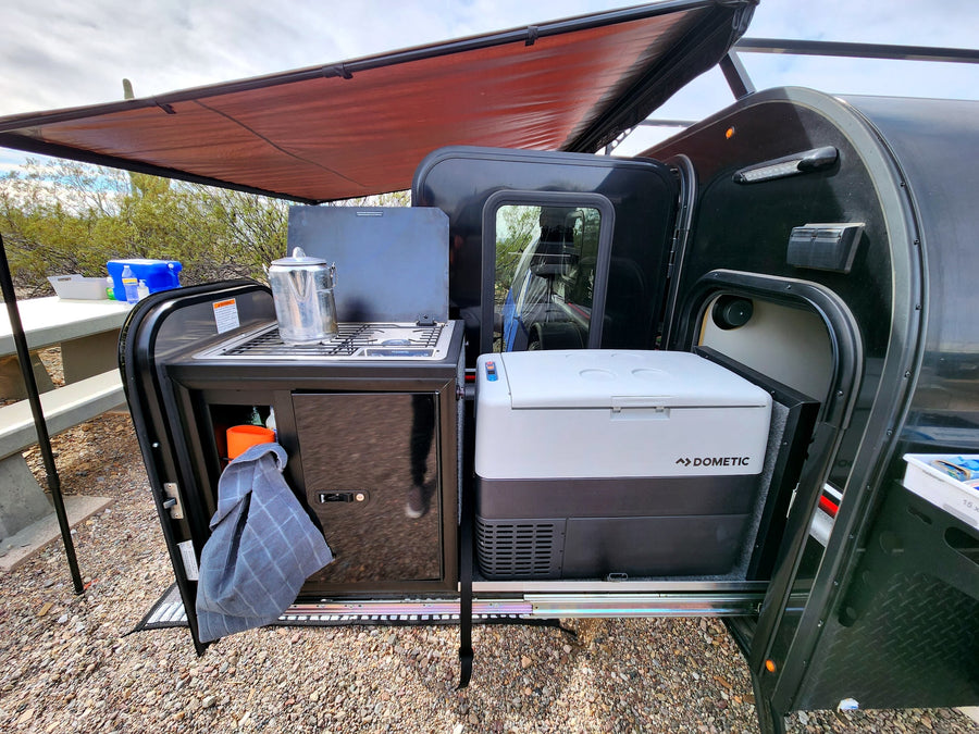 This RV rental's outdoor kitchen features a Dometic cooler, stove, and storage. Ready for camping!