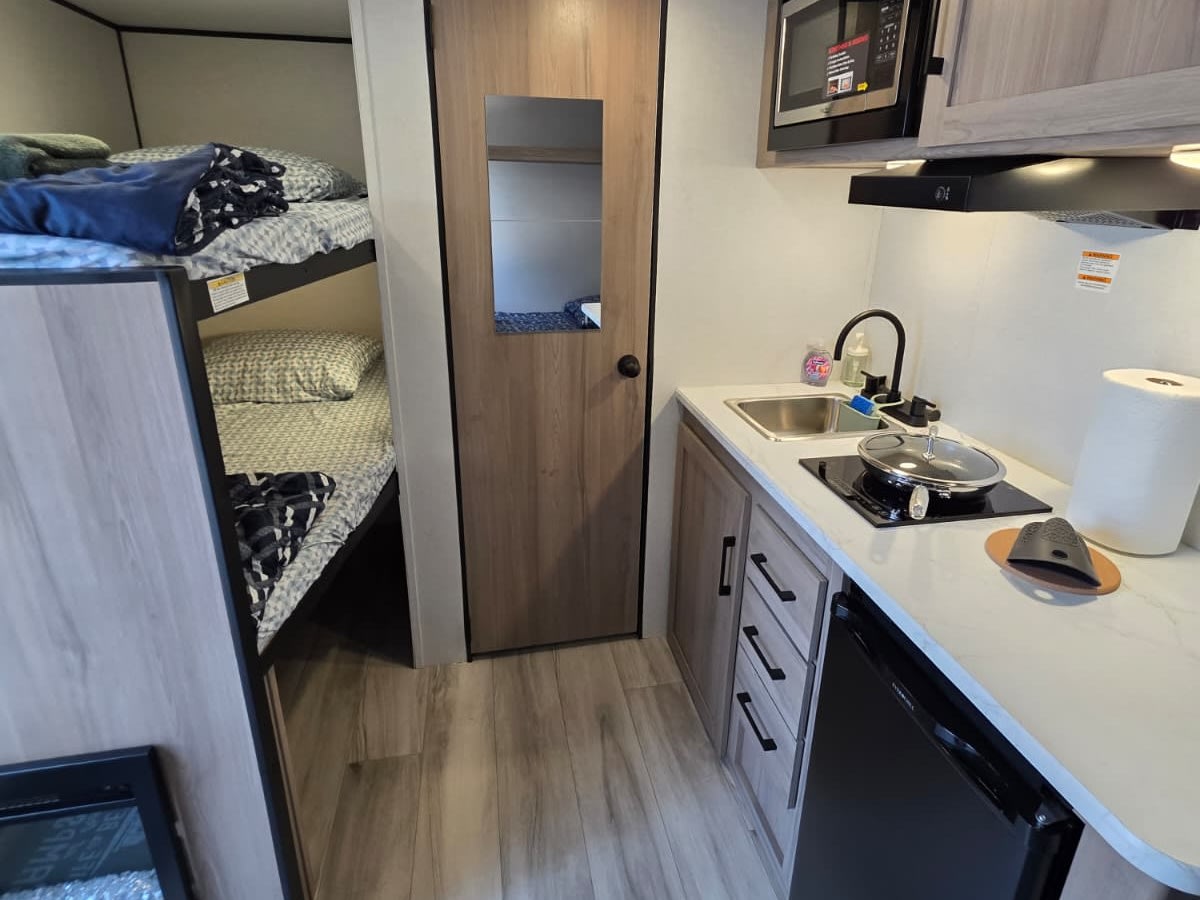 and a built-in fireplace.|This RV rental kitchenette features a compact sink — photo 10