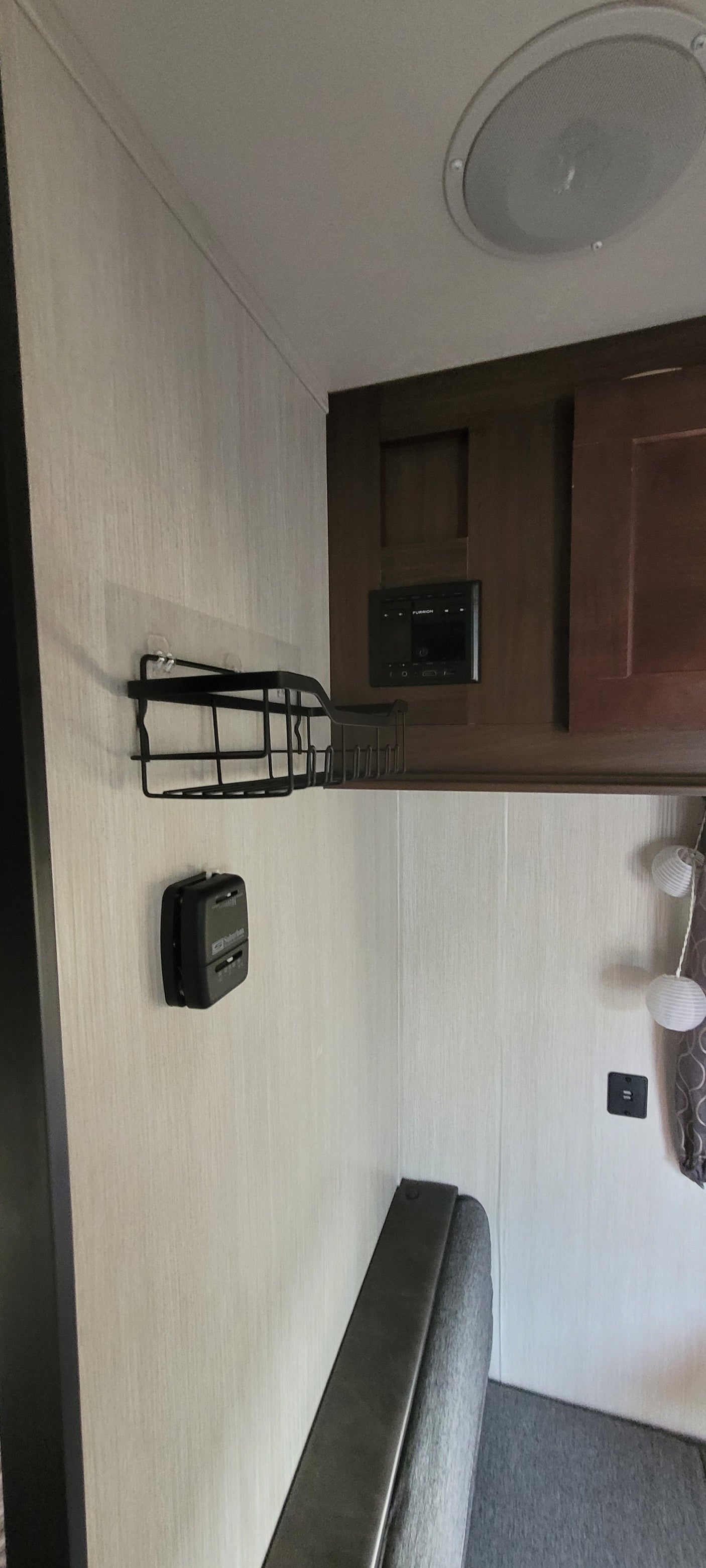 RV rental interior featuring a sleek counter, speaker, Furrion control panel, and comfy dinette seating.