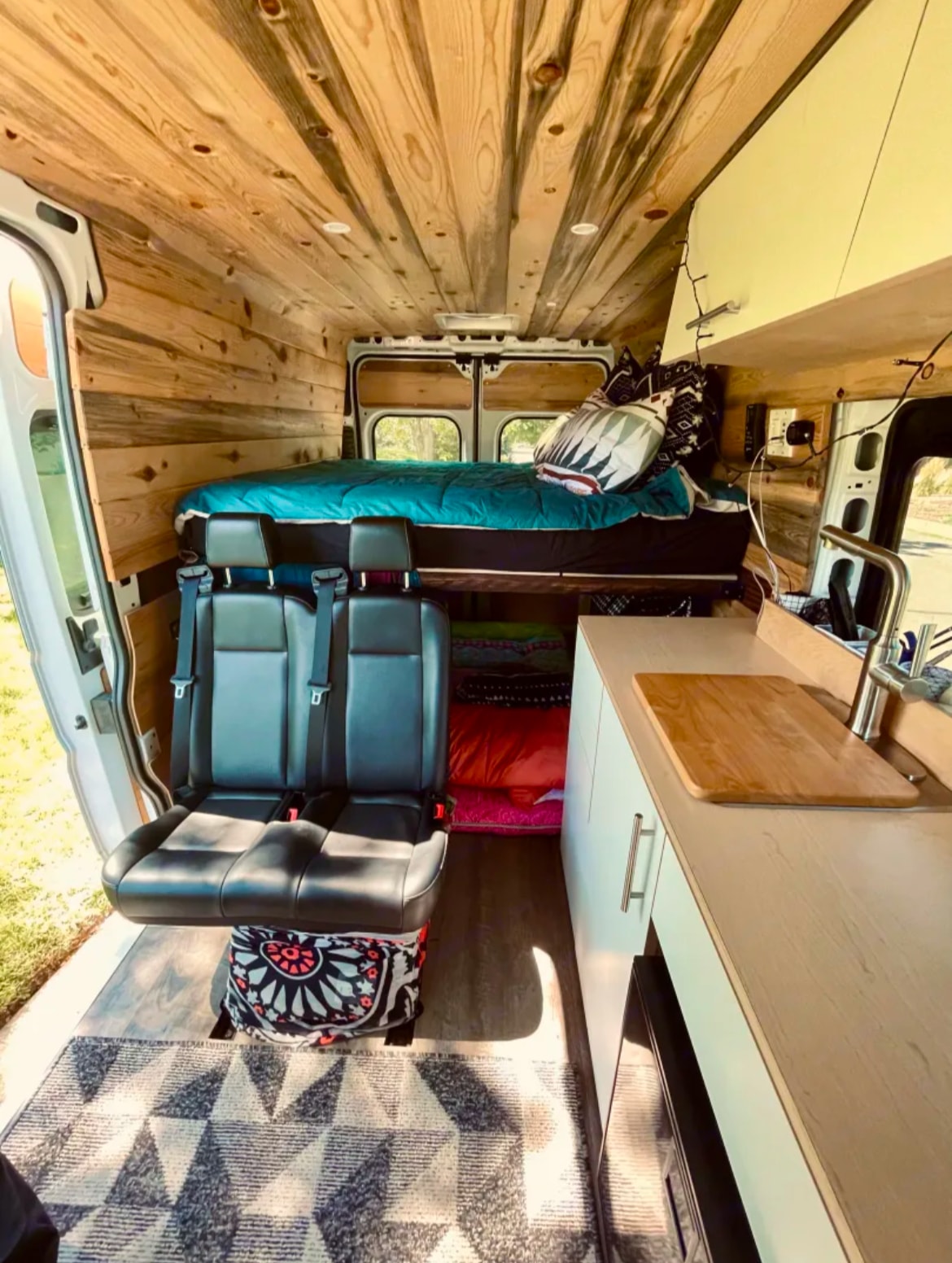 is parked by stunning red rock formations under a blue sky.|An RV rental