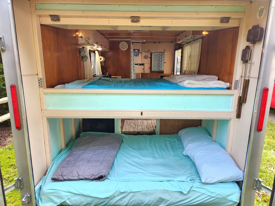 with solar panels & propane tank. Great for RV rental or mobile travel.|Cozy RV rental interior: elevated bed