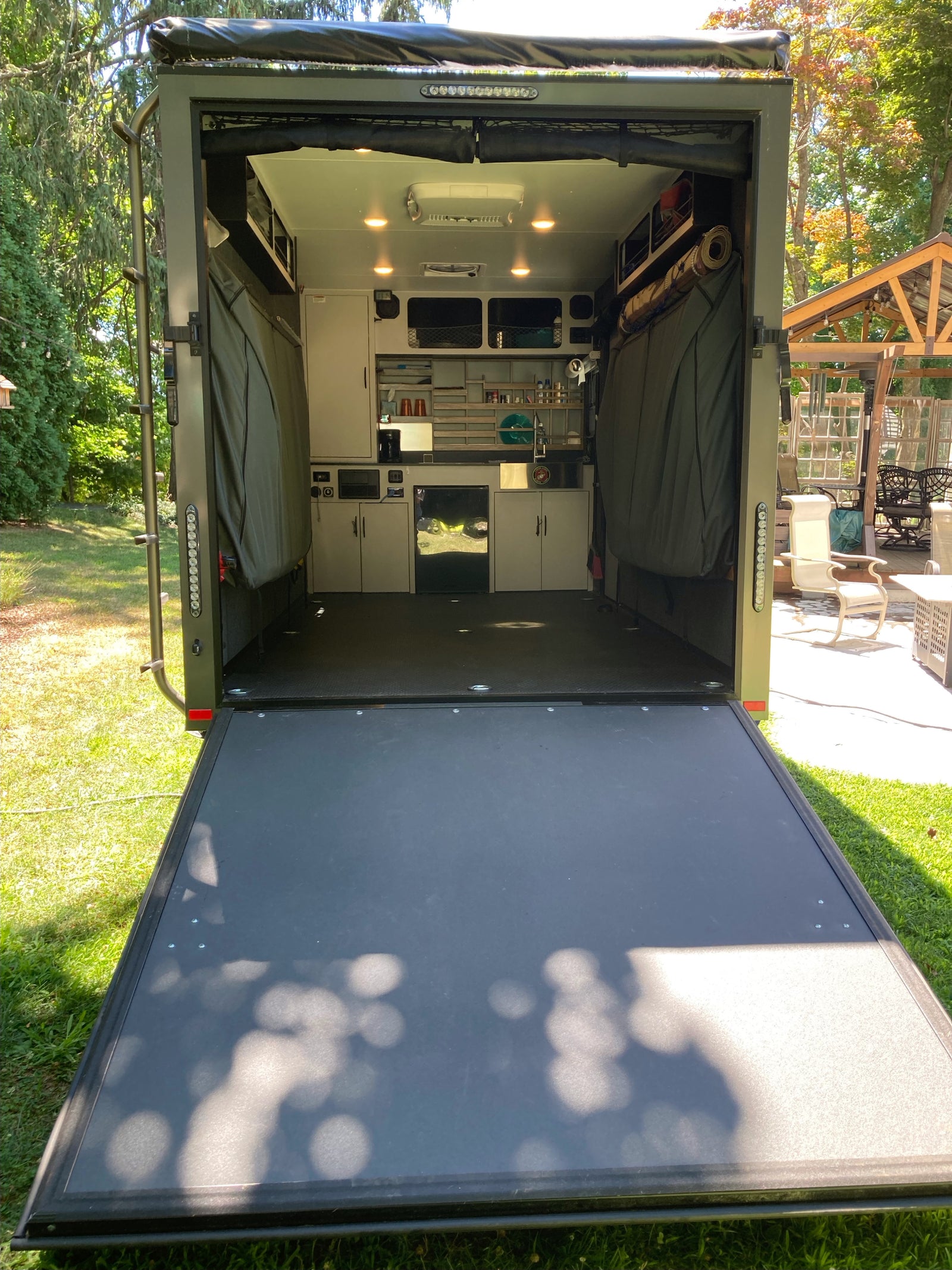 This RV rental is a converted cargo trailer, ready for adventure. Features a full mobile kitchen, sleeping areas, and a drop-down ramp.