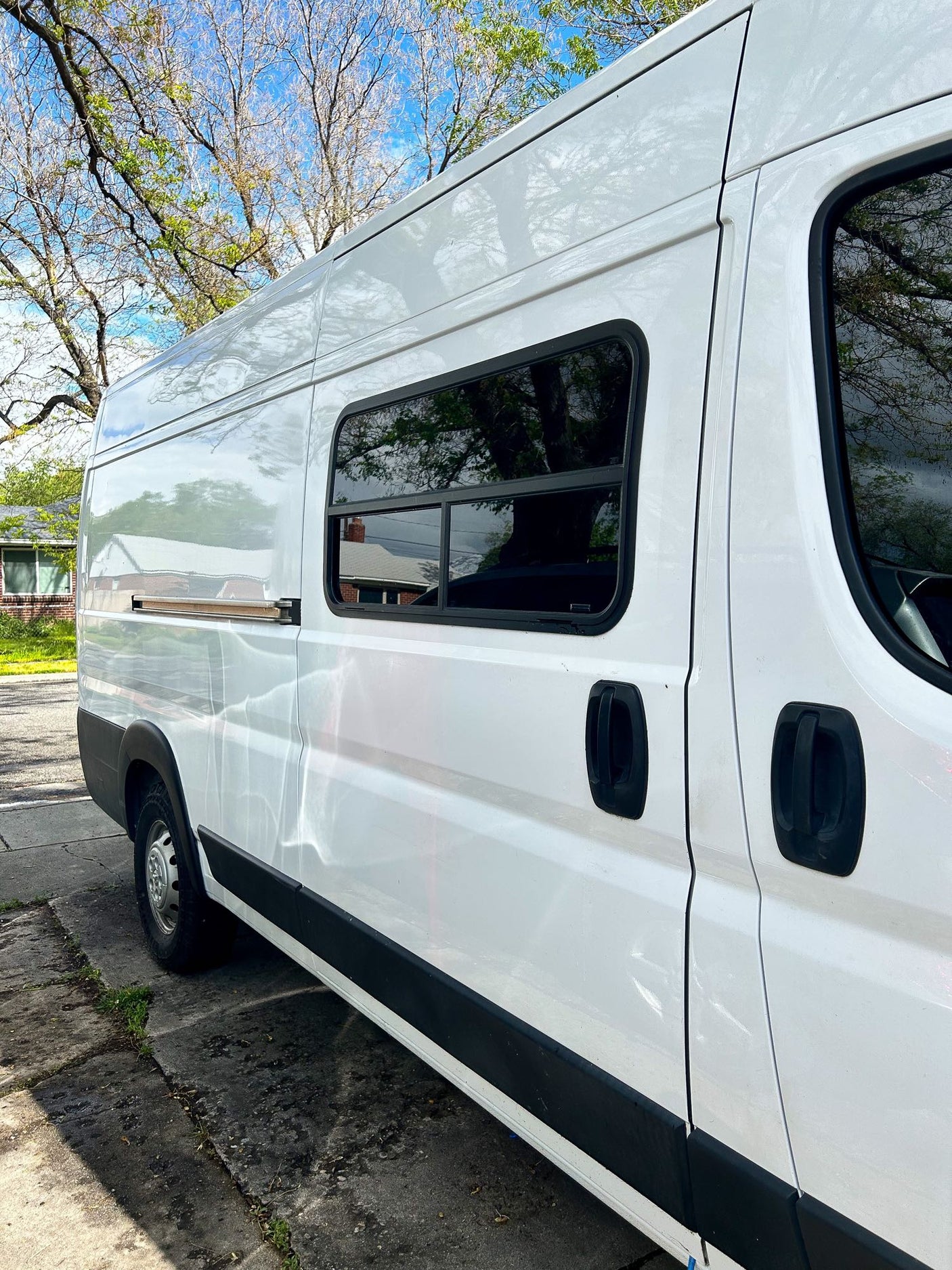 Gleaming white camper van, ready for an RV rental adventure. Parked under blue skies, perfect for van life travel.