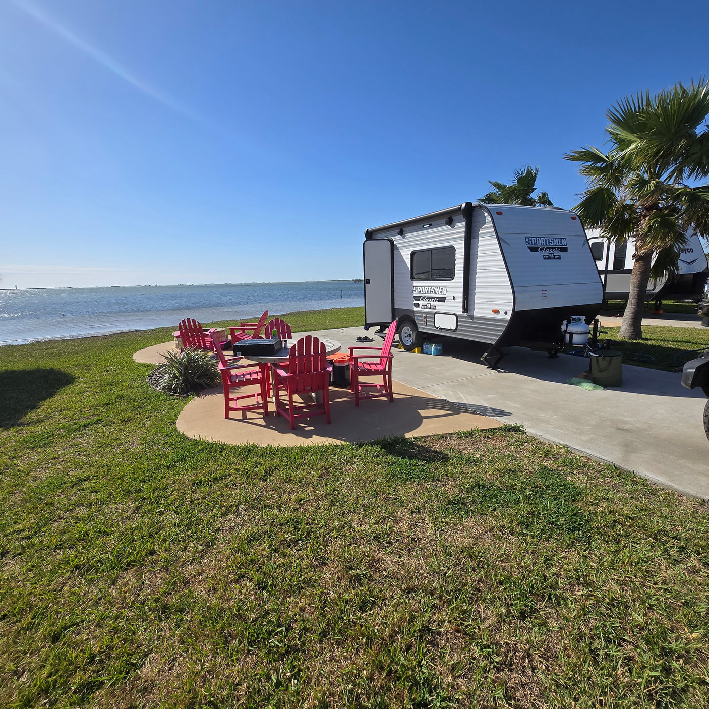 Enjoy your waterfront RV rental! This Sportsmen travel trailer offers a perfect campsite with bay views and cozy seating.