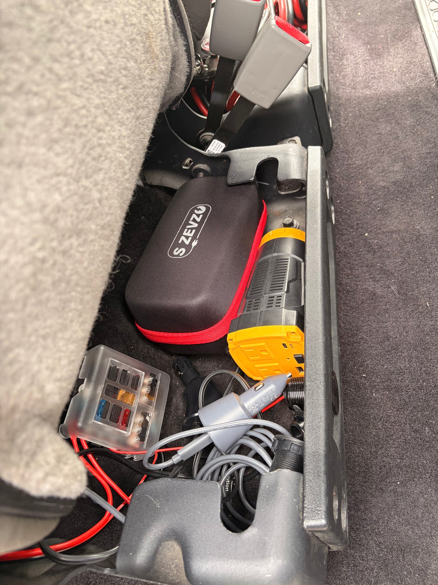 S ZEVZO power pack, compressor, fuse box, & car accessories in organized RV rental storage for essential vehicle power.