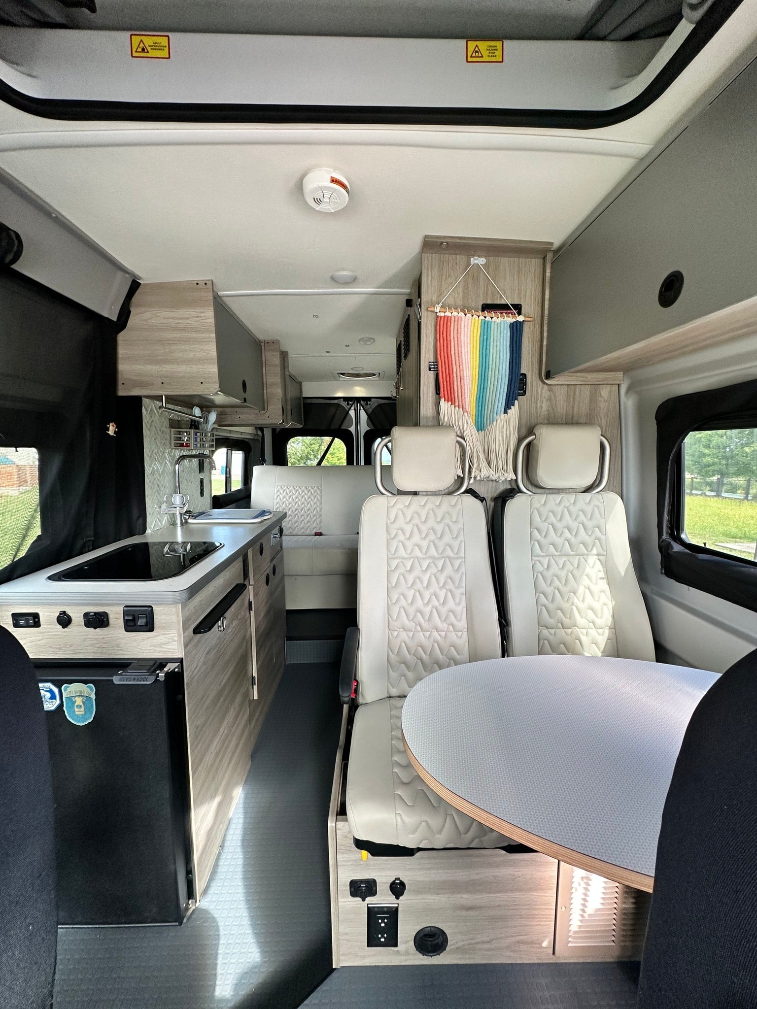 and comfortable front seats.|RV rental camper van interior: Compact kitchen with sink