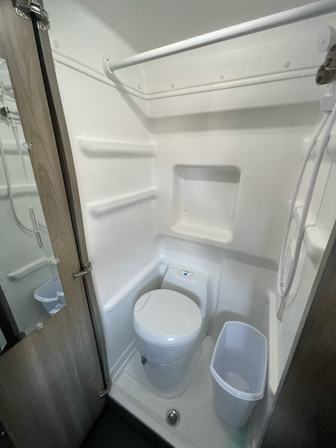 This RV rental wet bath offers a compact shower and toilet setup, perfect for comfortable travel adventures.