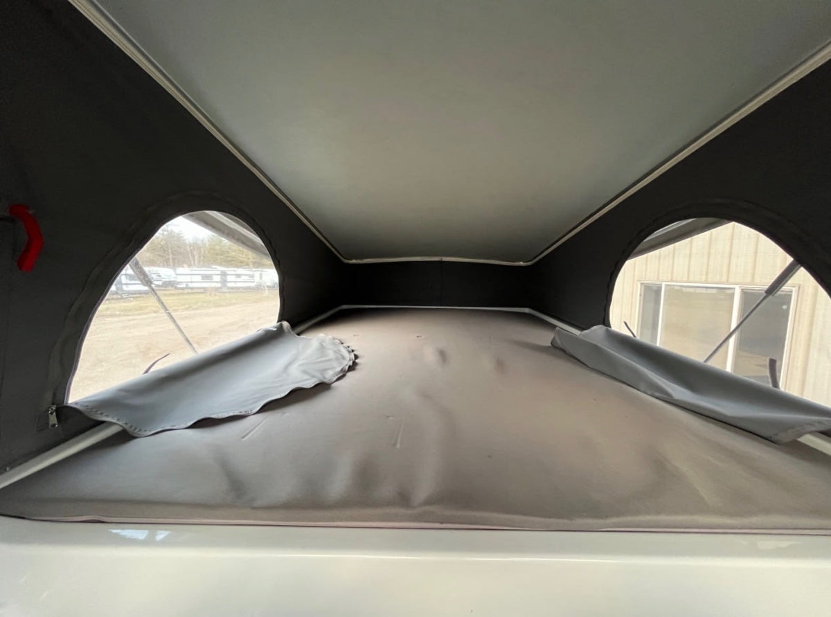 and pop-top access.|Rear view of a spacious RV rental camper van interior with comfy bed — photo 7