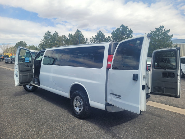 White Chevrolet Express van with open driver and rear doors, well-suited for an rv rental conversion or group transport.