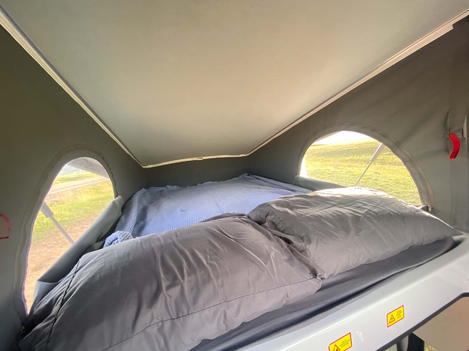 next to their RV rental campervan at a serene campsite.|Dusk at a desert campsite features an RV rental (Titus Adventure Co. campervan) next to a Joshua tree under a crescent moon.|Experience an RV rental: comfy bed