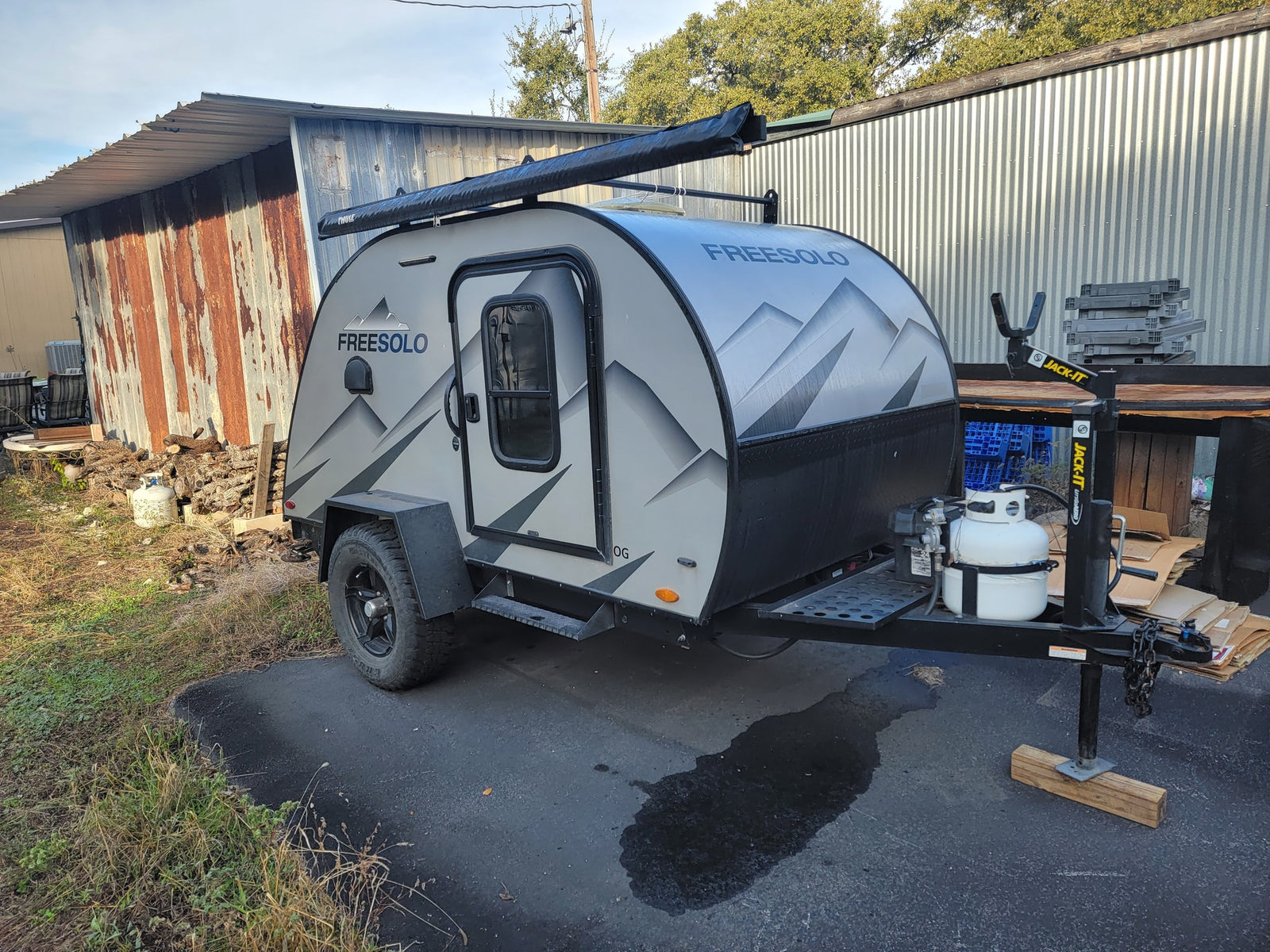 A sleek Freesolo teardrop camper, ideal for an rv rental adventure, is parked with its Thule awning ready.