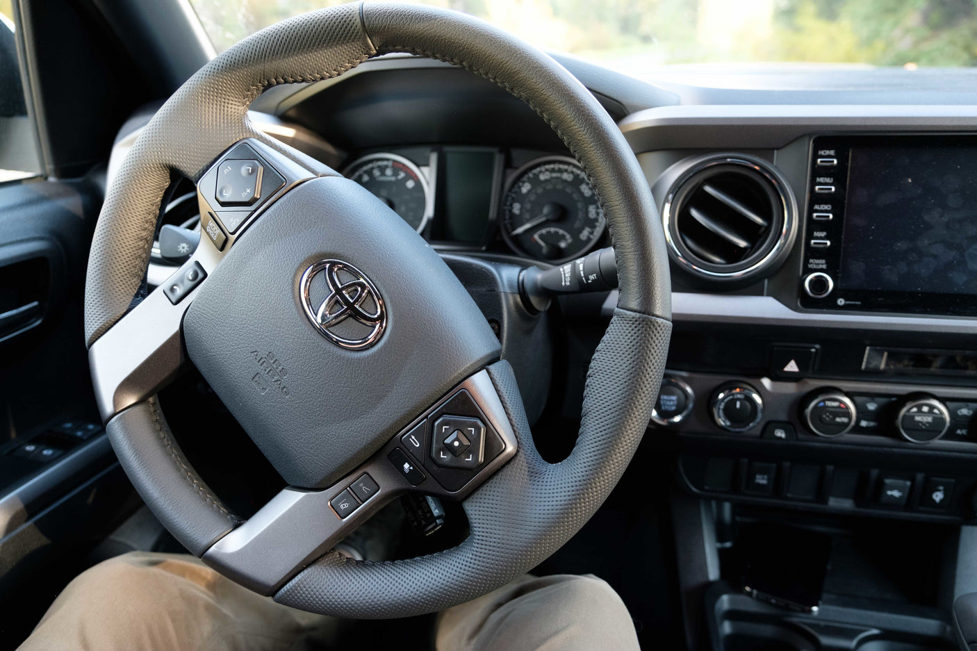 Inside a Toyota truck, a common choice for RV rental adventures, showing the steering wheel and dashboard controls.