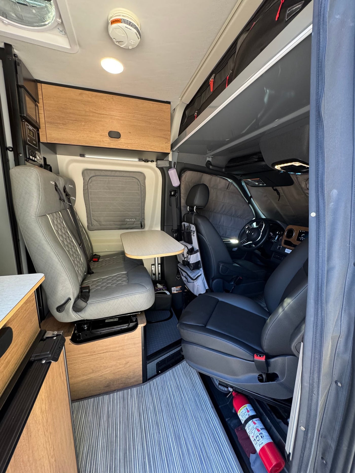 parked on gravel under sunny skies.|RV rental camper van with rear doors open — photo 14