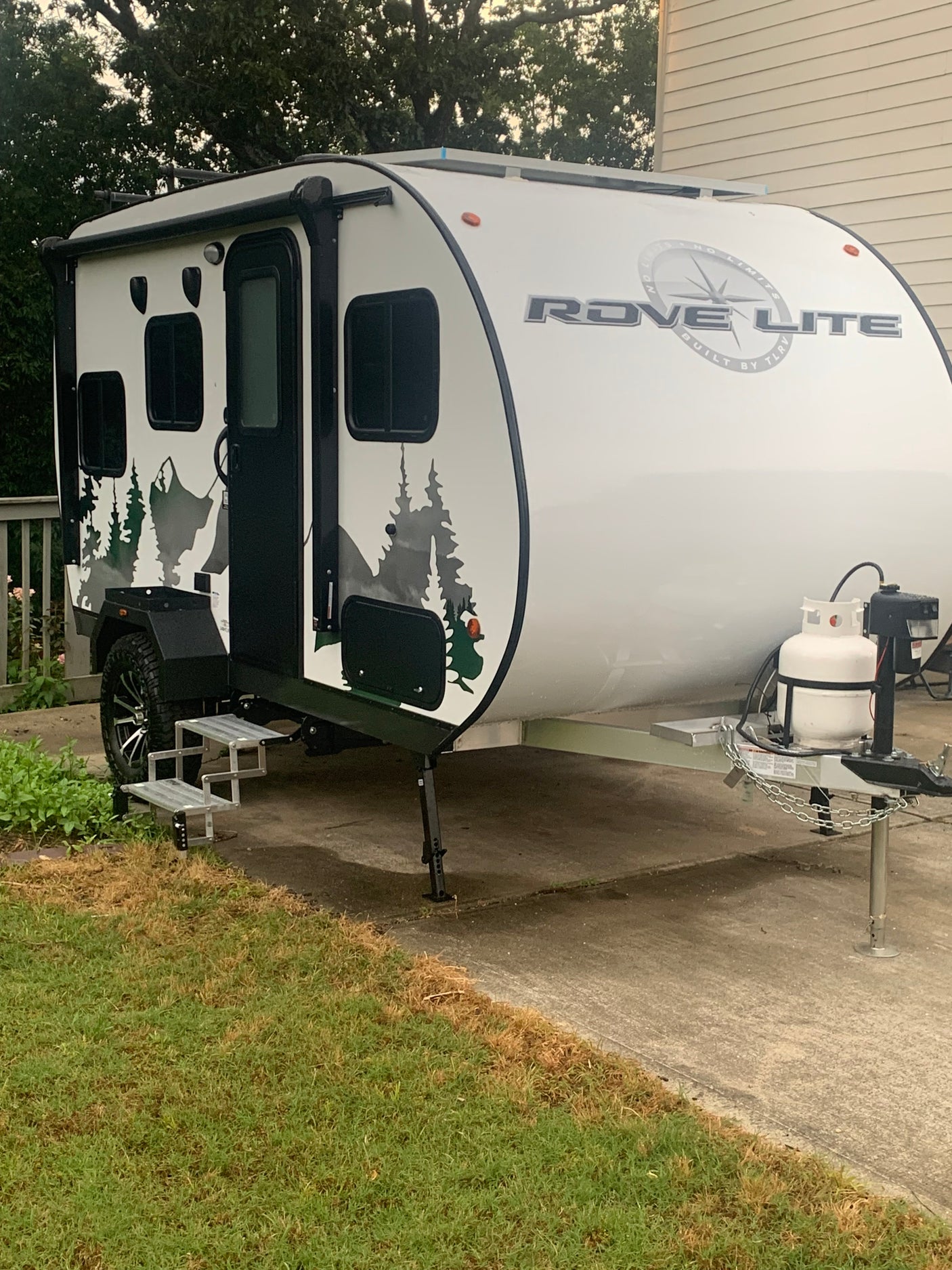 Experience outdoor adventure with this Rove Lite RV rental! A white teardrop travel trailer with cool mountain decals.