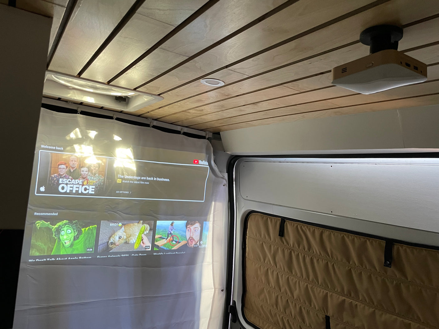 Enjoy mobile entertainment in an RV rental with this ceiling-mounted projector casting onto a curtain screen. Perfect for cozy viewing!