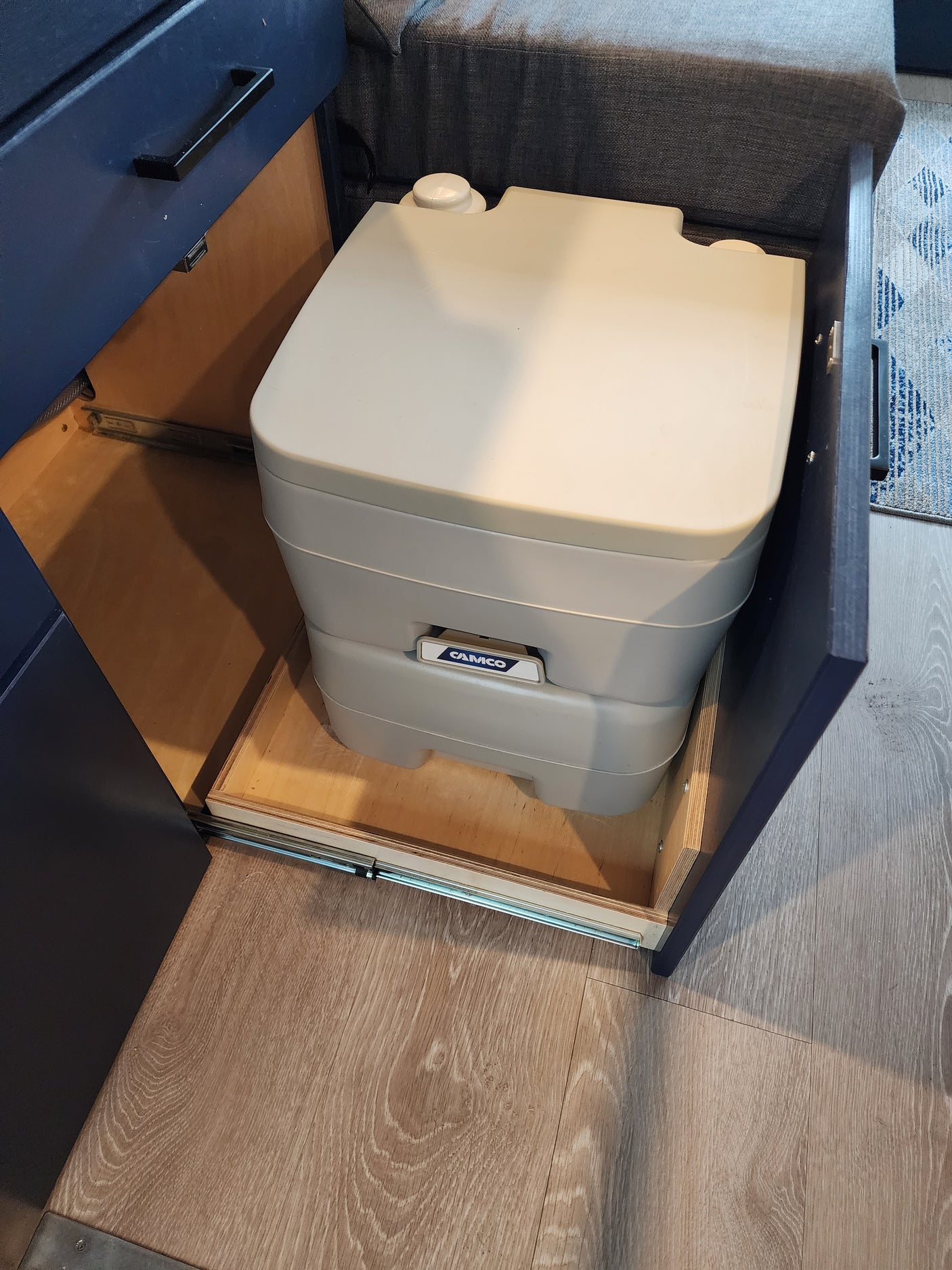 This RV rental features a portable toilet neatly stored in a pull-out drawer, maximizing space efficiently.