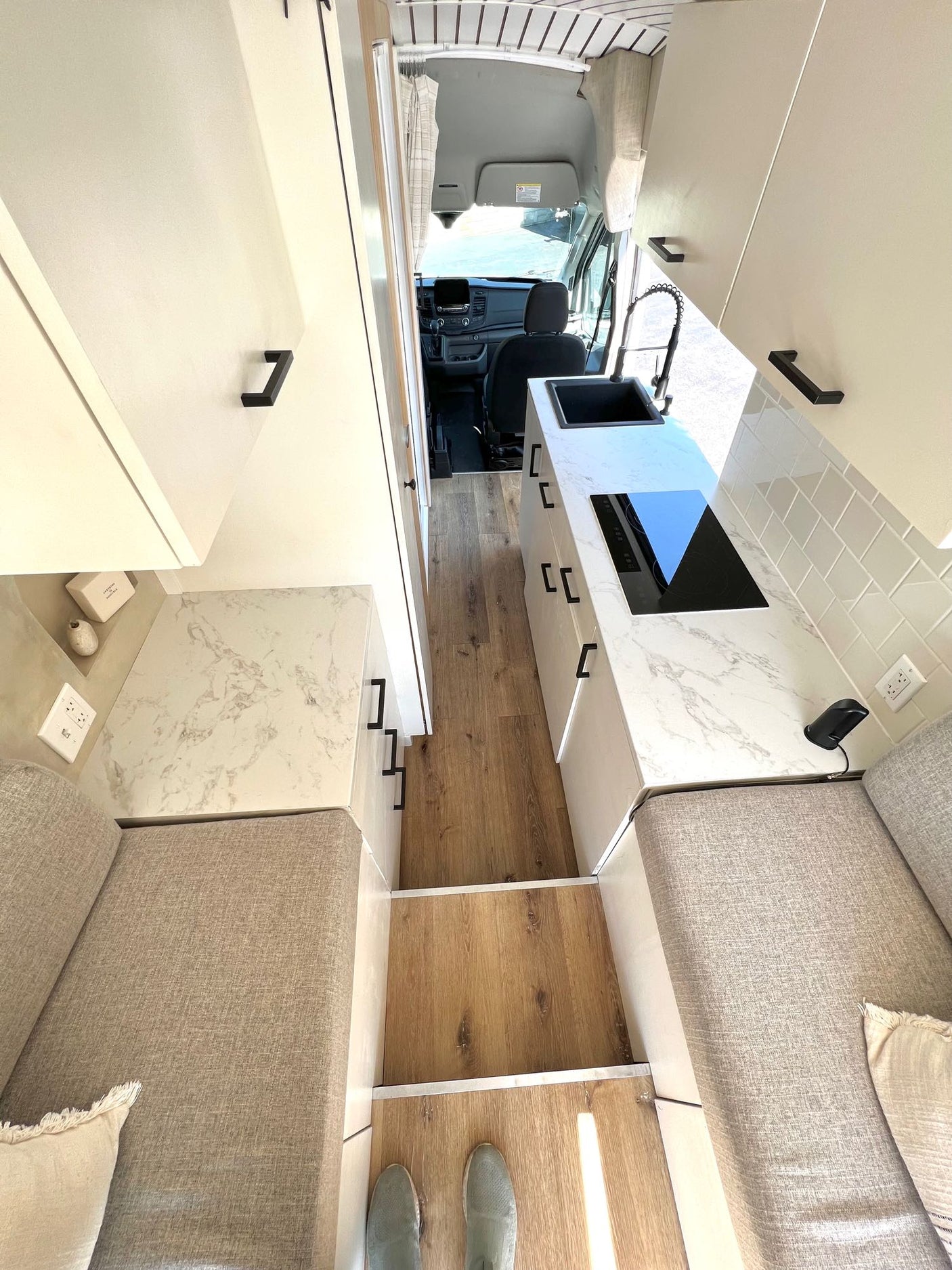 and tiled walls with a wood mat.|RV rental's modern vehicle interior: dashboard features a large touchscreen
